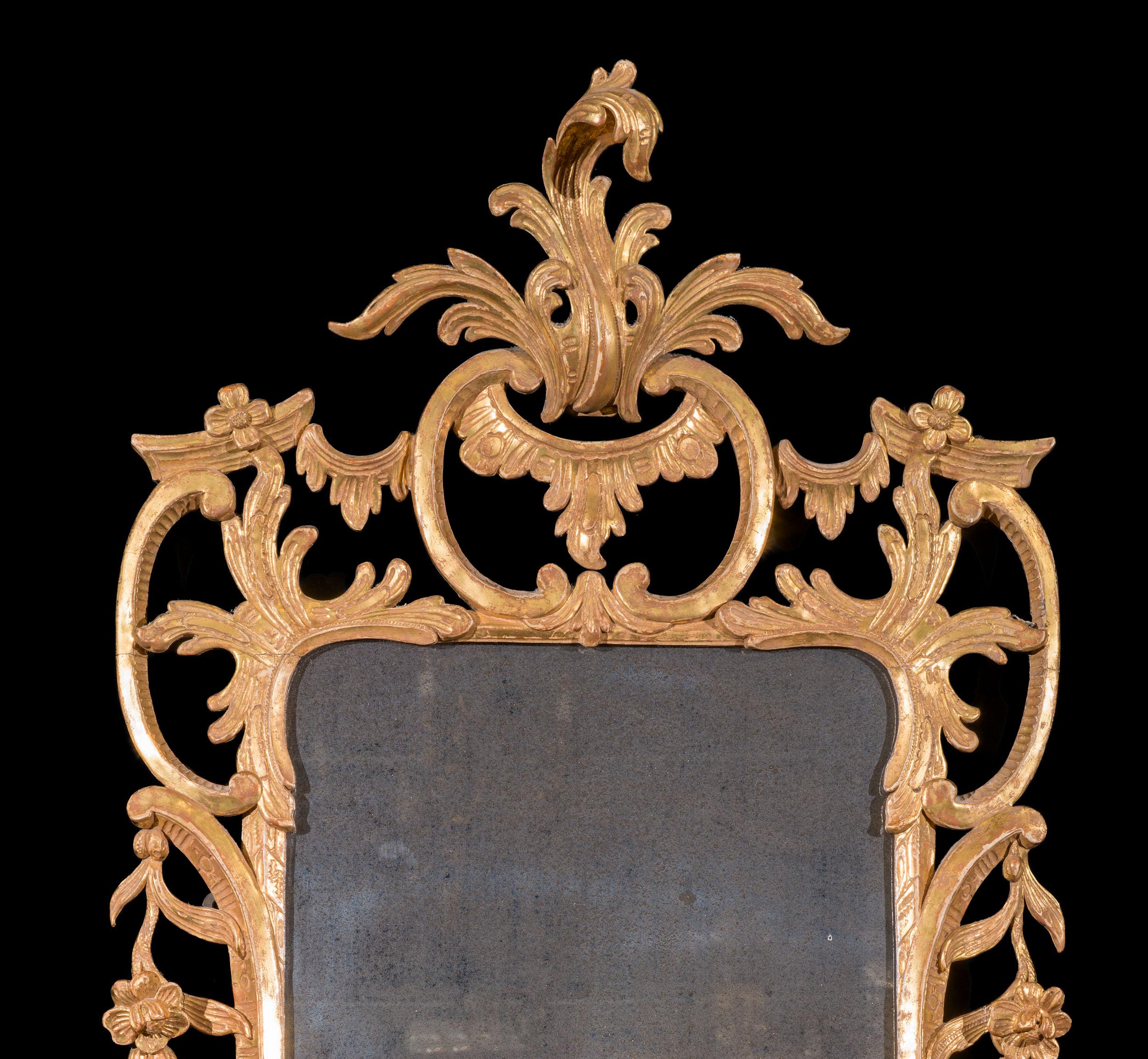 A fine gilt gesso George III wall mirror with delicate carving. The intricate frame has fine detailing throughout, including a well carved and delicate crest of foliate form and flowering vines and foliage within a framework of c scrolls. Mercury