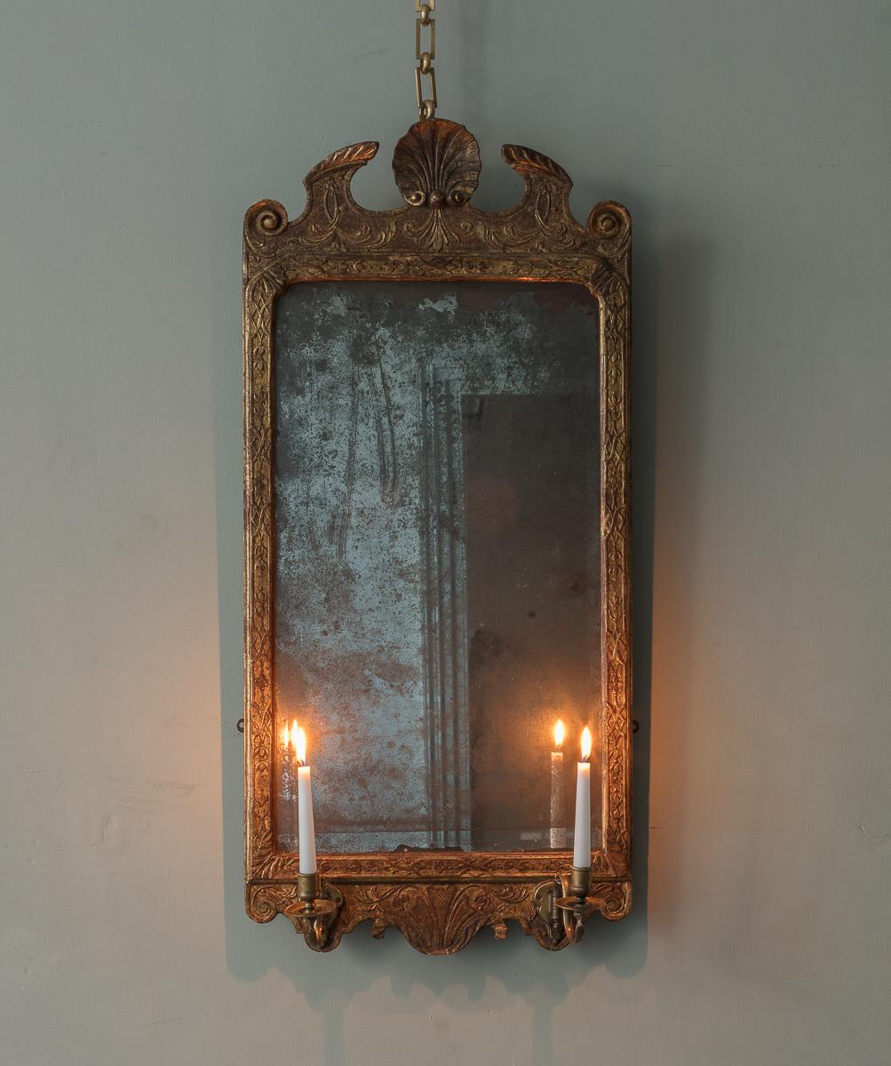 Specchio da molo di George Fox III in legno dorato di dimensioni modeste, con frontone a collo di cigno spezzato con cresta centrale a conchiglia, sopra fregio intagliato a foglie d'acanto, con lastra originale in vetro smussato con riflesso al