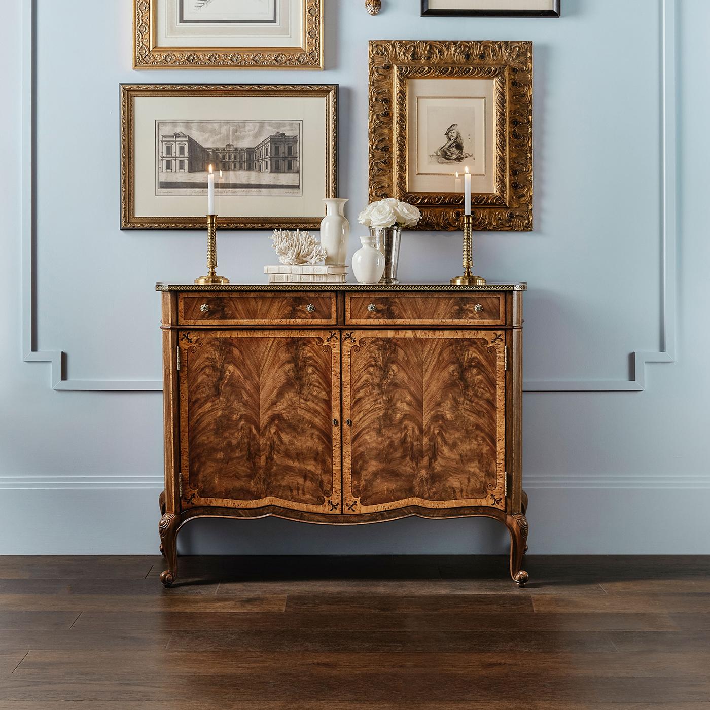 An embodiment of classic elegance and refined craftsmanship. This exquisite piece is crafted from exotic figured woods, showcasing a rich blend of textures and grains. The cabinet is detailed with a timeless brass inlay that beautifully frames the