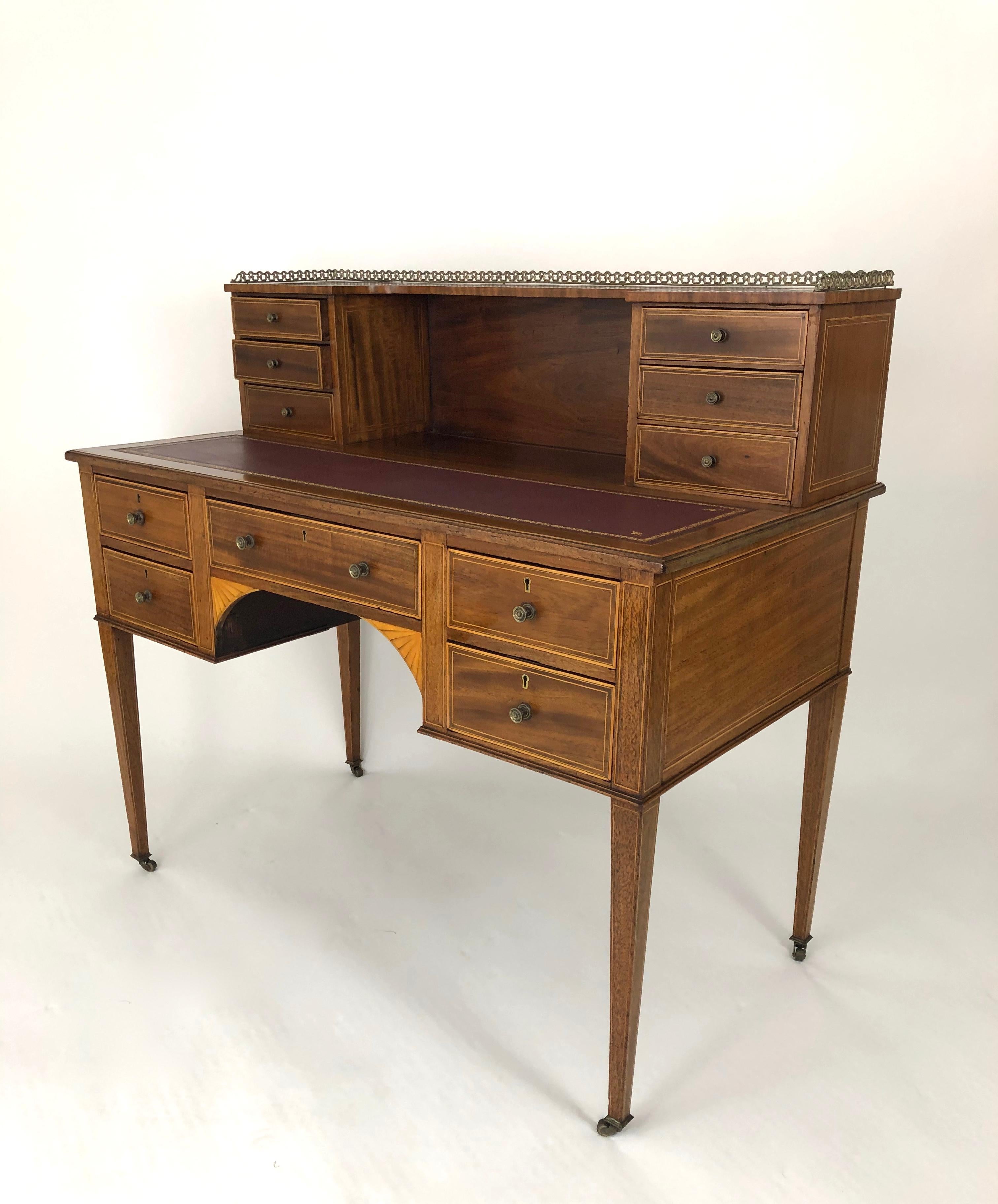 A fine quality and versatile George III inlaid mahogany writing desk, English, circa 1800, the super structure with brass gallery supported by two banks with three drawers each over a beautiful gold stamped burgundy leather writing surface below