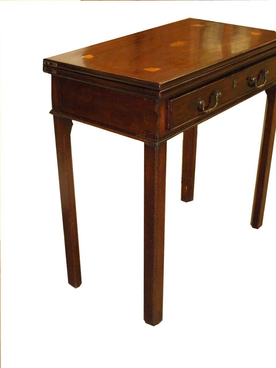 English Inlaid George III game table, the top with beautiful patina has a central conch shell inlaid medallion surrounded by convex corner fans connected with boxwood inlay. The hinged flip top is supported by one back swing leg; single drawer with
