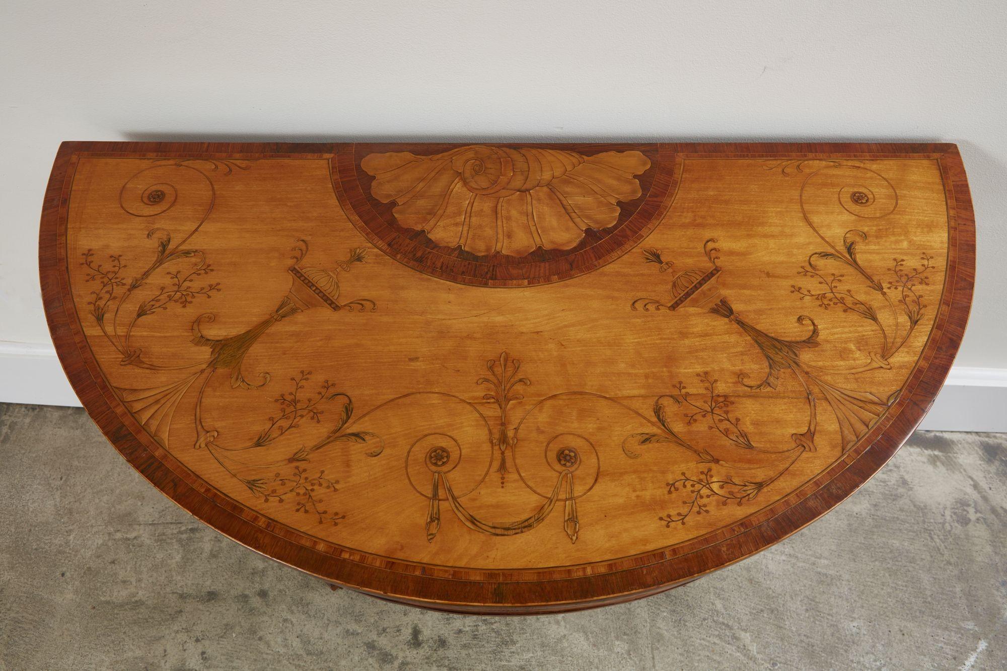 Sehr feiner, Mayhew und Ince zugeschriebener Kartentisch aus satiniertem Holz mit Intarsien aus George III. Die Platte ist reichlich mit Muscheln, Urnen, Säcken, Geißblatt und anderen neoklassizistischen Motiven intarsiert, die Schürze ist mit