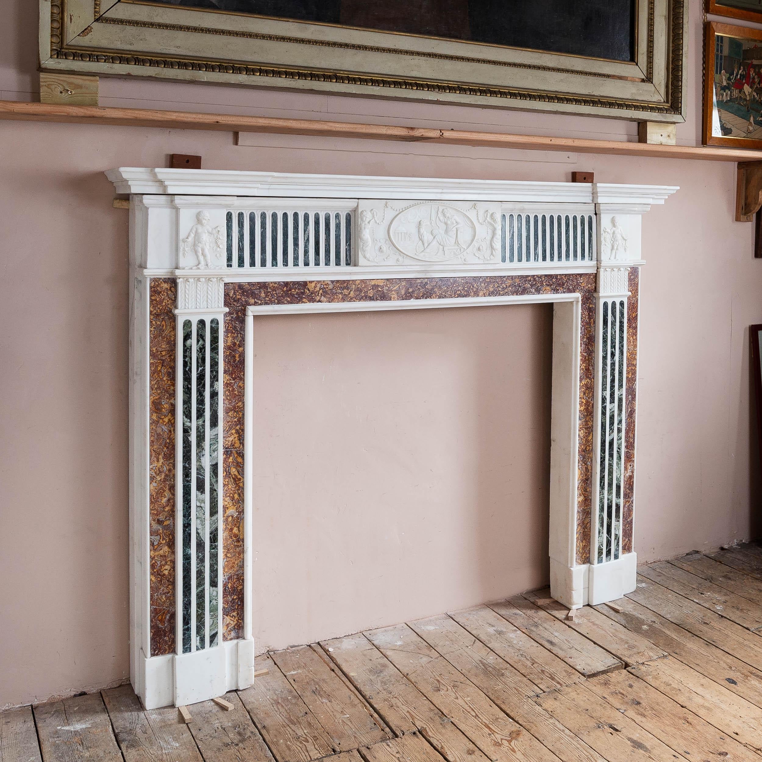 A George III inlaid Statuary marble fireplace, removed from a property on Belgrave Square, London, the moulded breakfront shelf above central tablet depicting Diana the Huntress and her dog, set within oval panel with winged putti to either side,