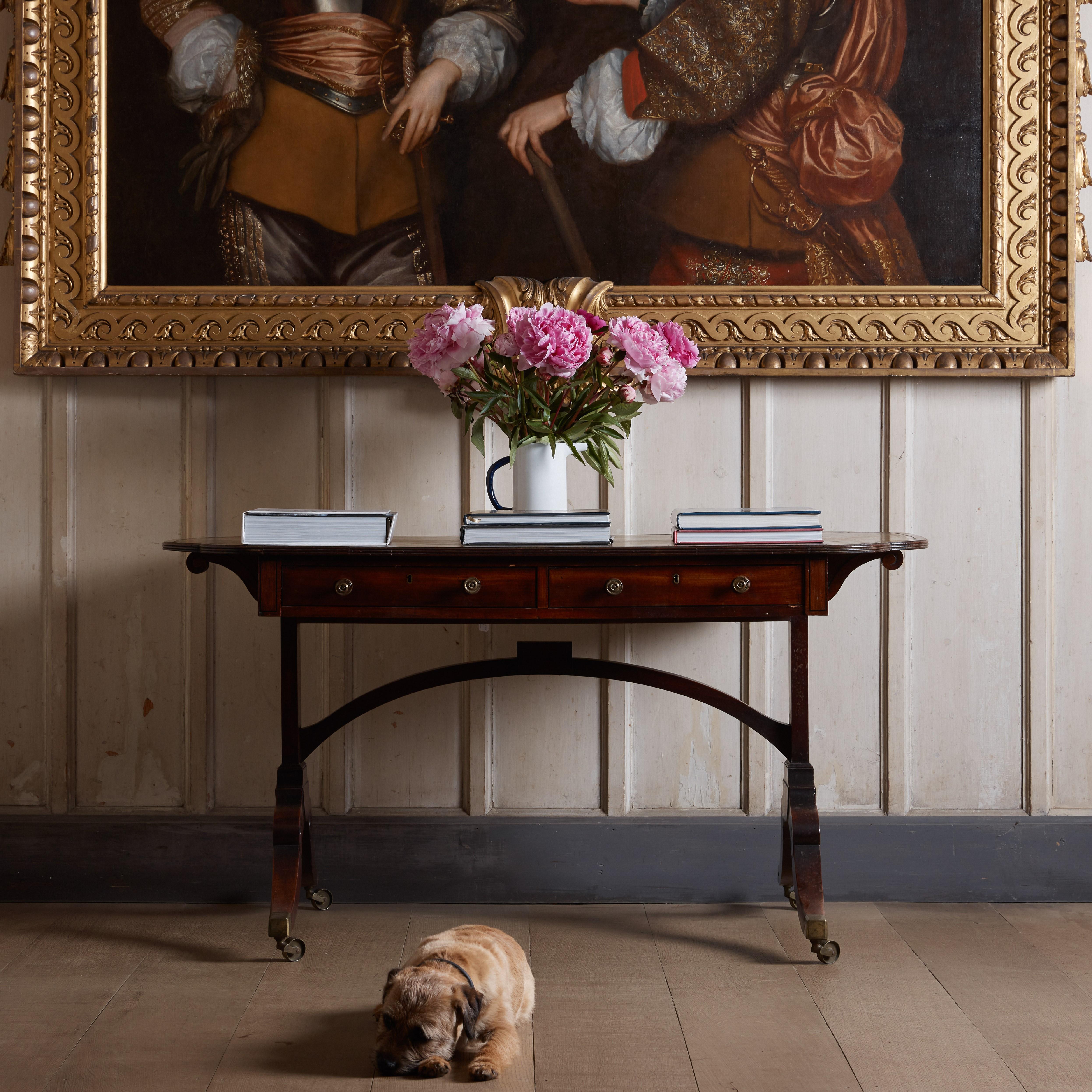 Une étonnante et rare table de bibliothèque de George III, vers 1810, avec un plateau en cuir d'origine présentant une magnifique patine d'aspect vert-de-gris. Une paire de tiroirs en frise à l'avant et de faux tiroirs à l'arrière, sur un magnifique