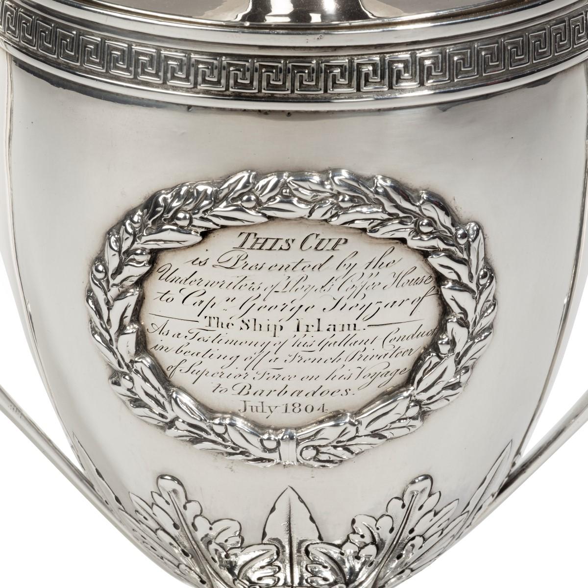 George III Lloyds patriotic fund silver and silver gilt vase and cover by Samuel Hennell, of Adam design, the lift-off cover with knop finial above angled swept handles and laurel wreath cartouche inscribed ‘This cup is presented by the underwriters