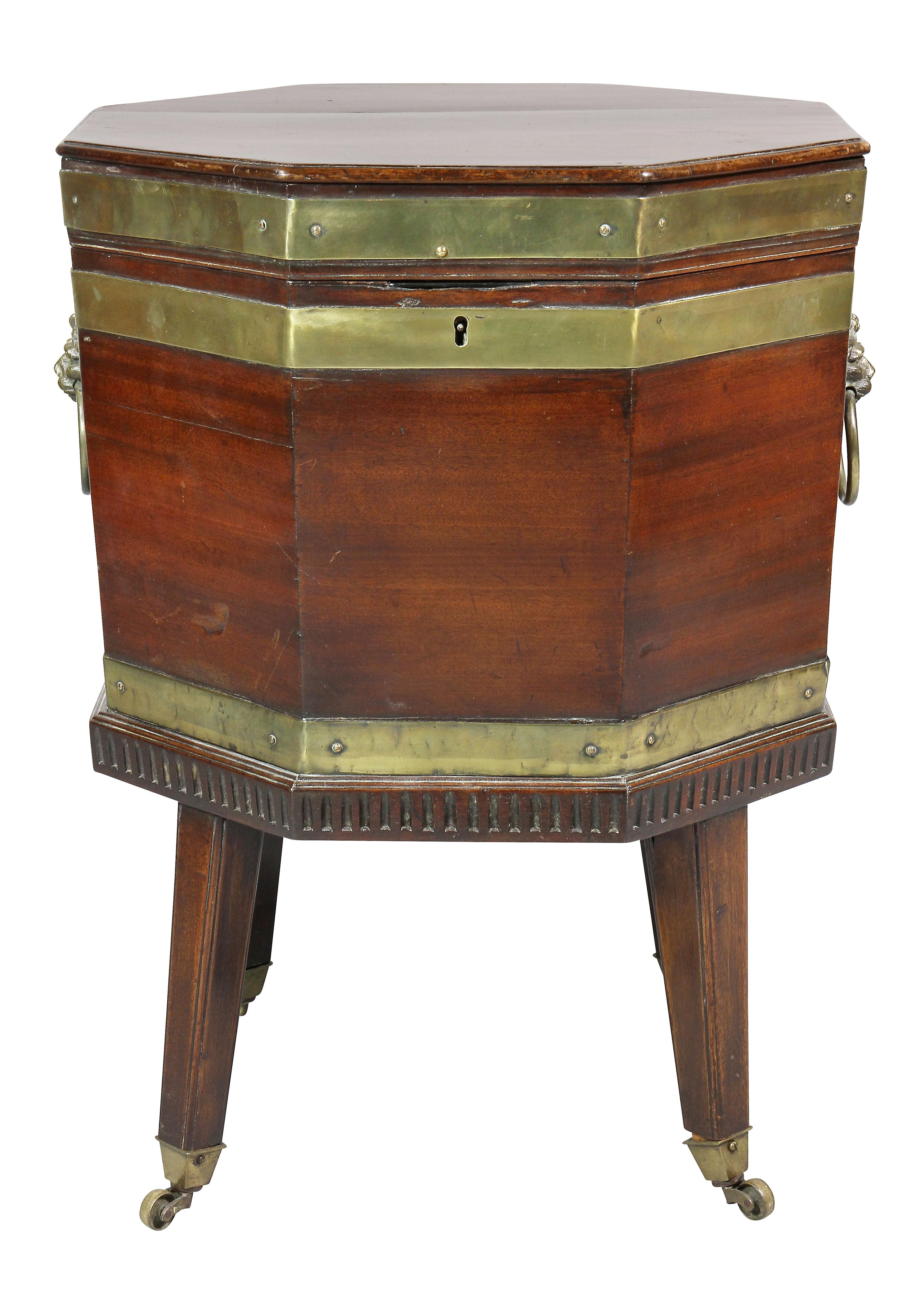 Octagonal hinged top over a conforming case with copper liner, lions head and ring handles raised on square tapered legs with casters.