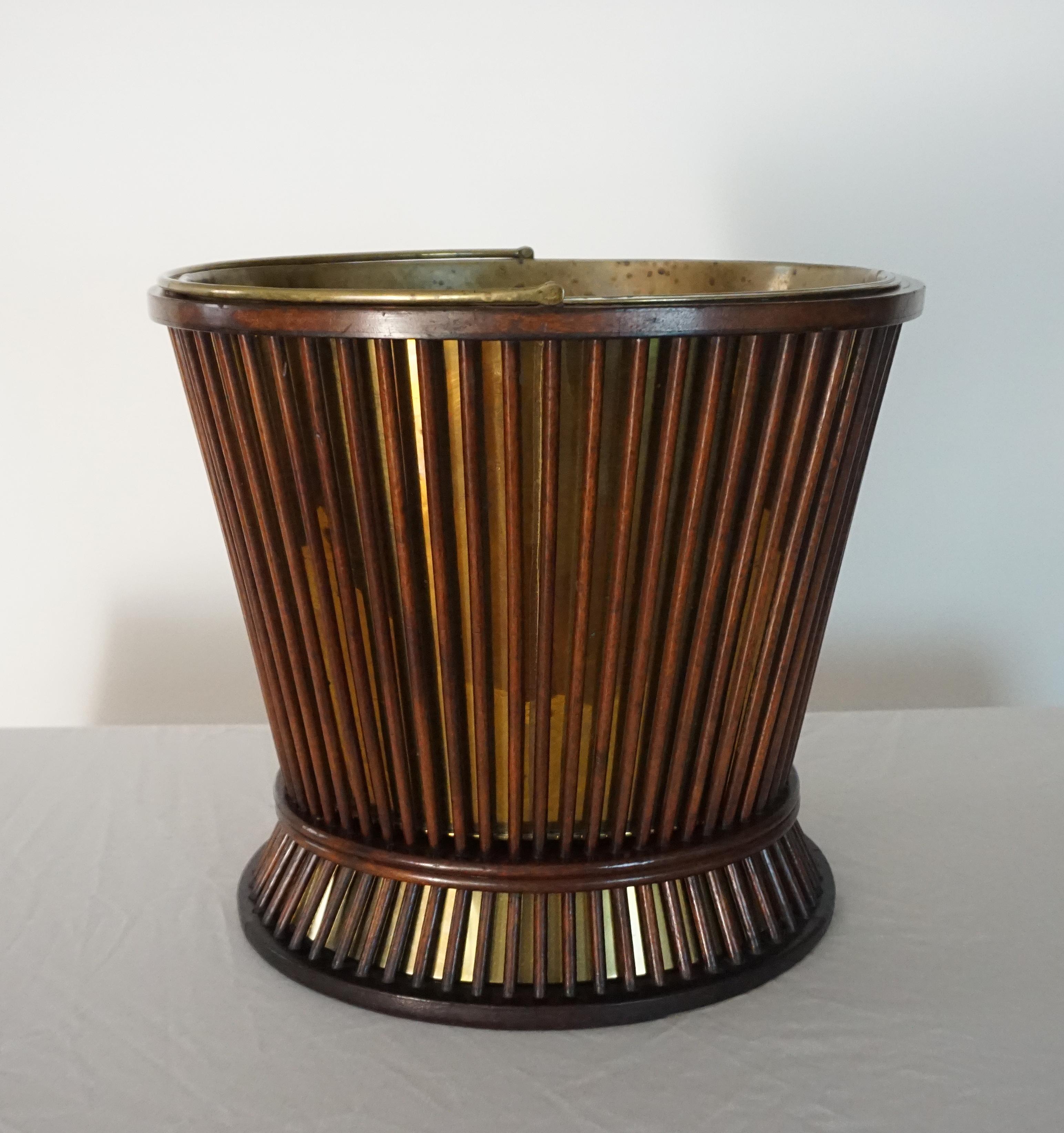 A rare and unusual George III circa 1800 peat, turf, coal, or kindling bucket of 'waisted' form having top handle and mahogany reeded spindle design with original brass liner inserts both top and bottom. Can also be repurposed as a very chic waste