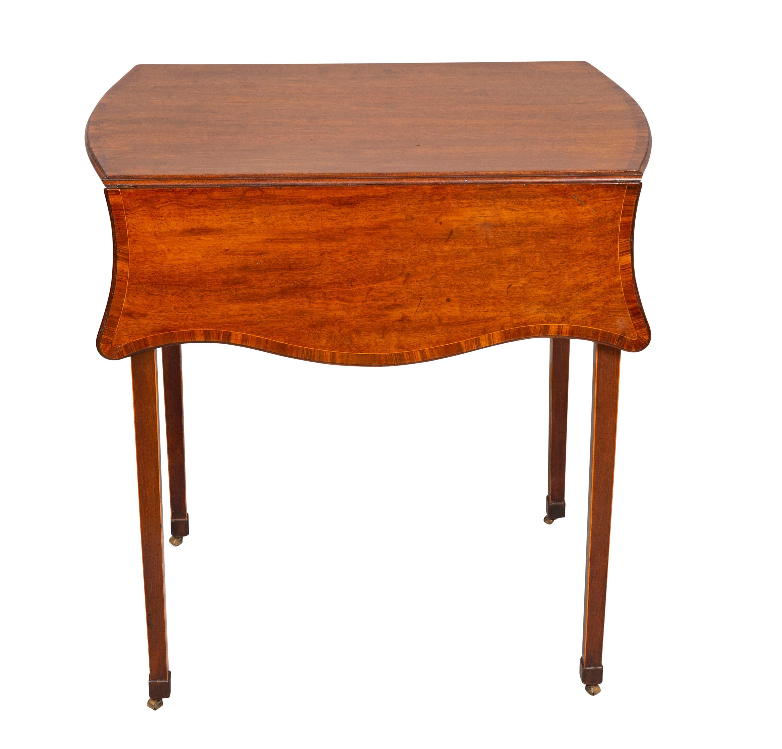 Rectangular top with a pair of serpentine drop leaves all with banded edge over a frieze containing a drawer, raised on square tapered legs and casters.