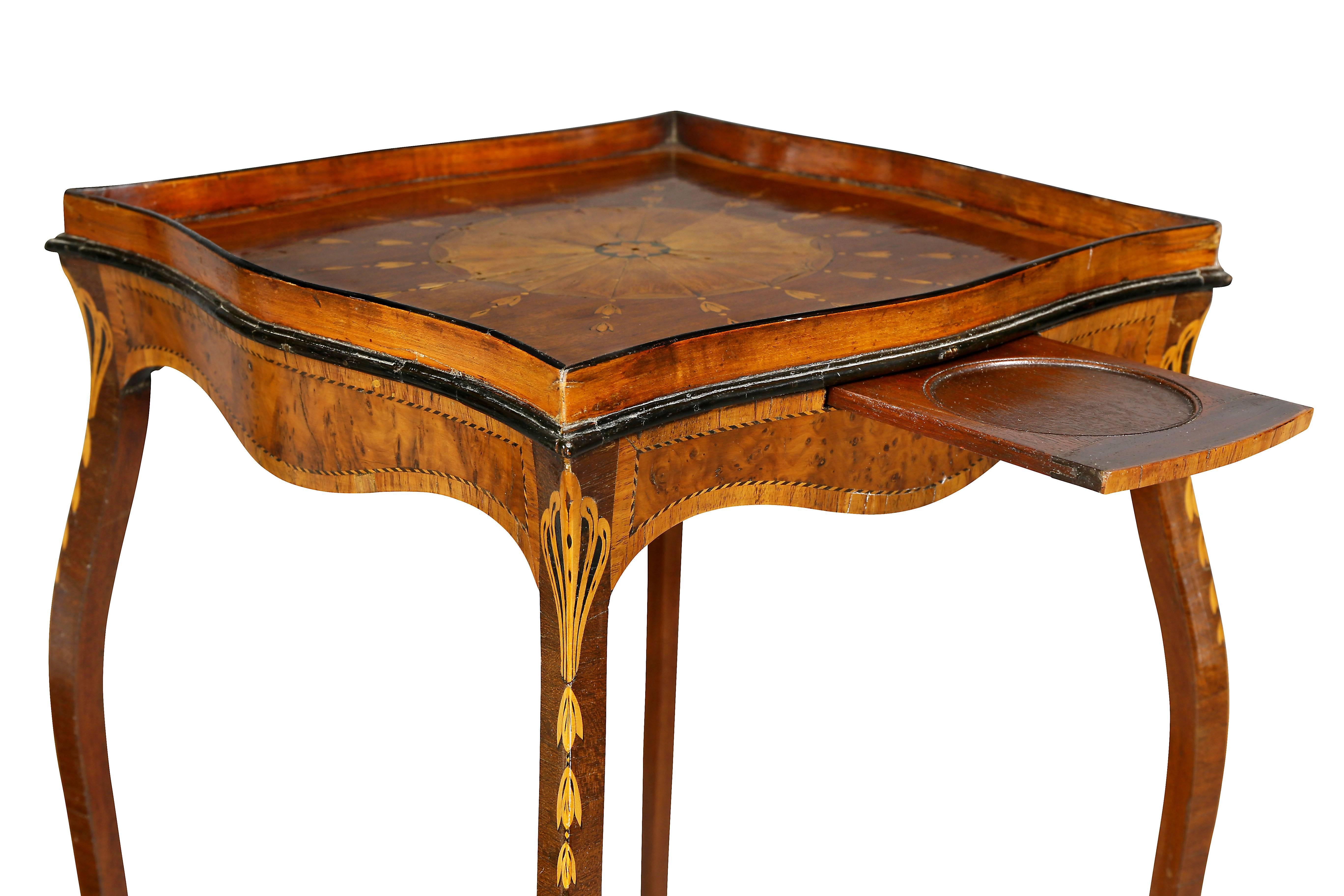 Most likely by Ince and Mayhew. Shaped square top with central satinwood inlaid paterae and conforming gallery over a conforming frieze with yew wood veneers, delicate cabriole legs inlaid with bellflowers and later X stretcher.