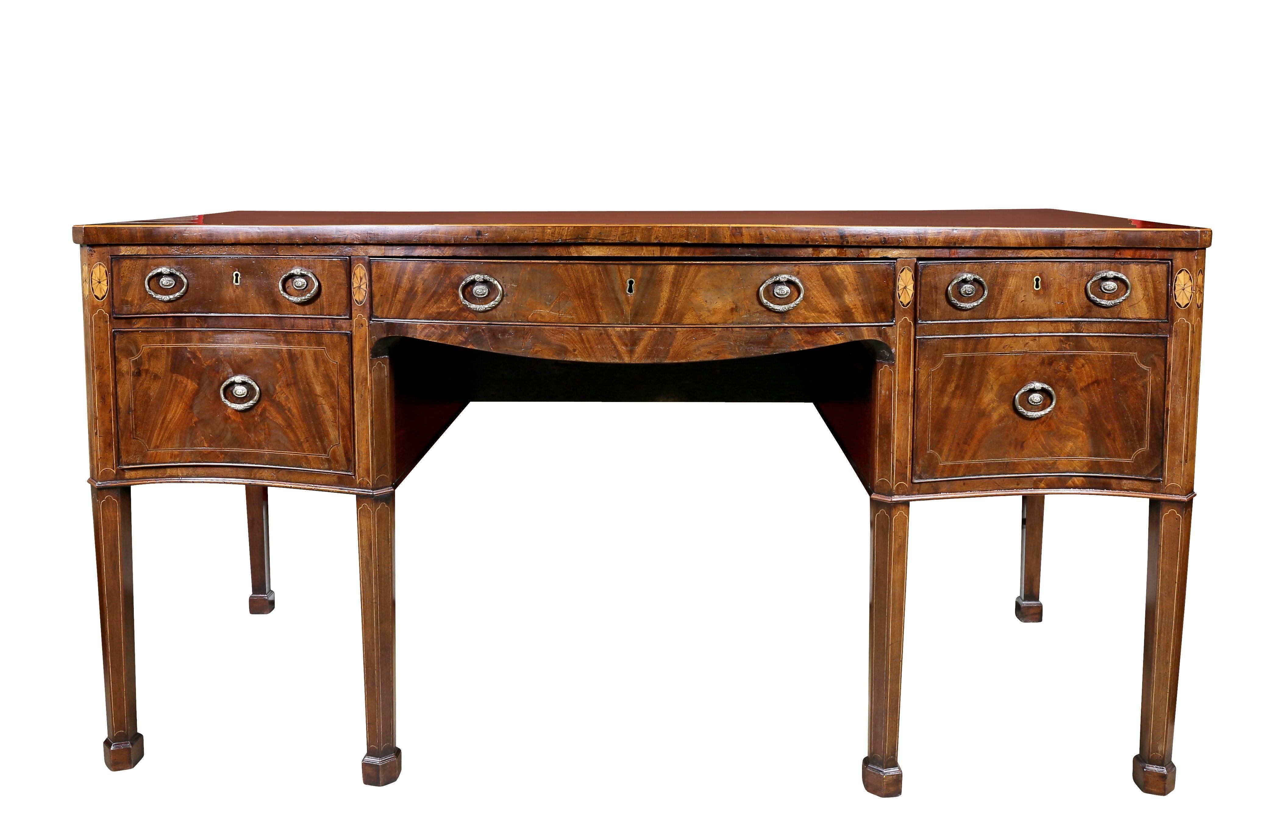Serpentine shaped rectangular top over a central drawer flanked by two deep drawers , the sides with false drawers with one working drawer, raised on square tapered legs headed by paterae, block feet. Probably by Gillows of Lancaster. Top shows