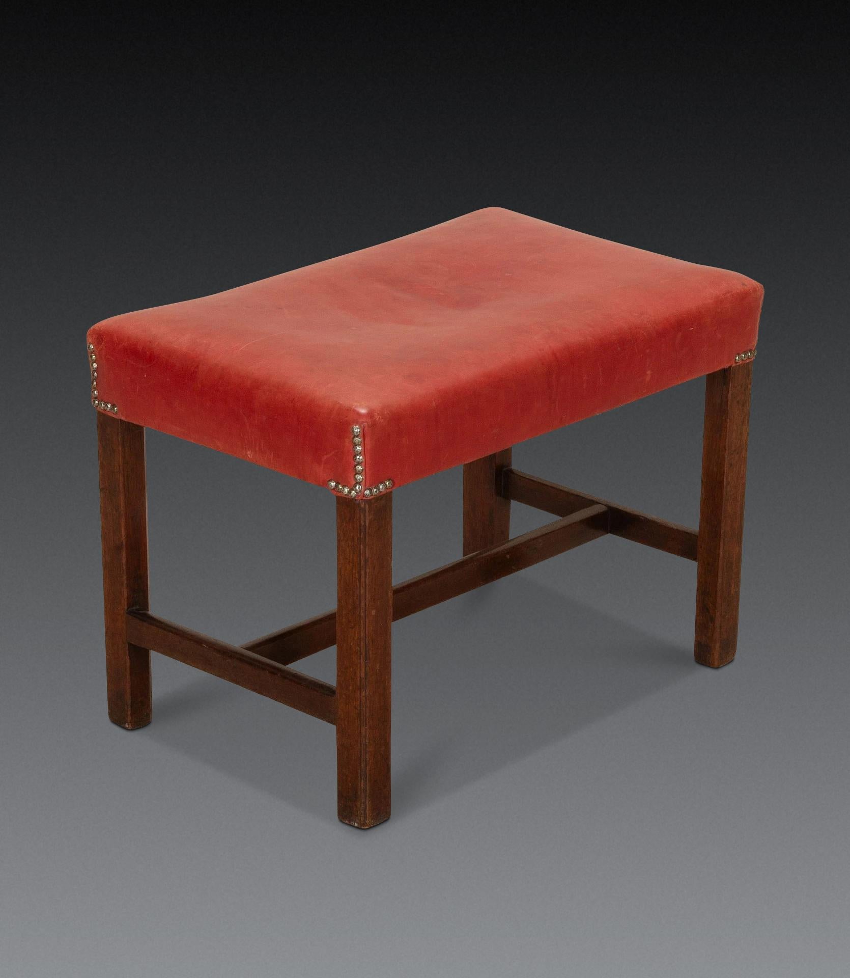 Tabouret à pieds carrés en acajou du XVIIIe siècle, avec des châssis en H et recouvert de cuir rouge ancien avec des clous en laiton. Circa 1760. Intelligent et robuste, avec des rails d'origine.

H : 46 cm (18 1/8