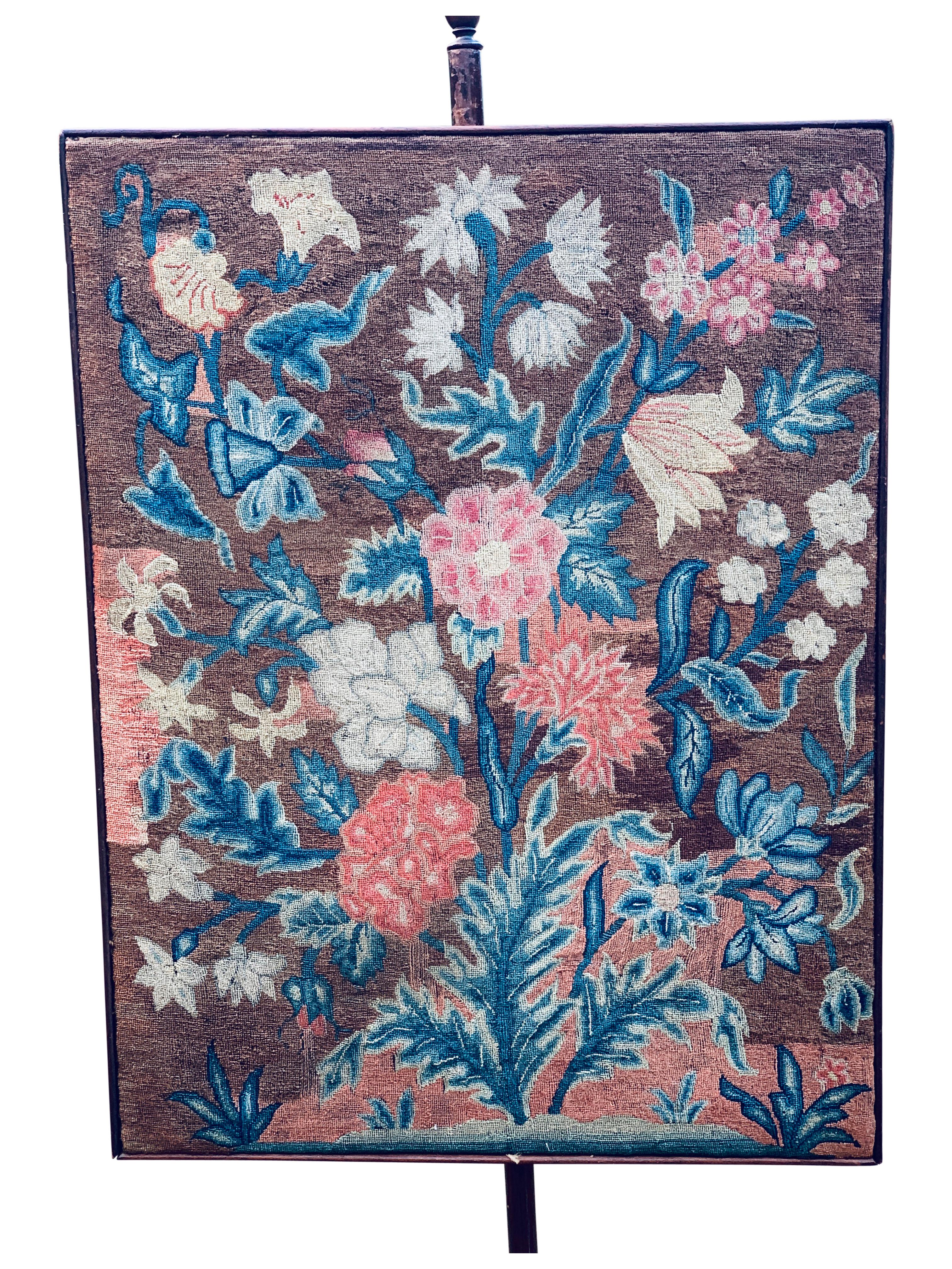 This is a choice model of a pole screen with a beautifully designed and embroidered needlework panel that one might find on an 18th Century model. 
Carved standard with cabriole legs ending in slipper feet. The dimensions here are approximate, so