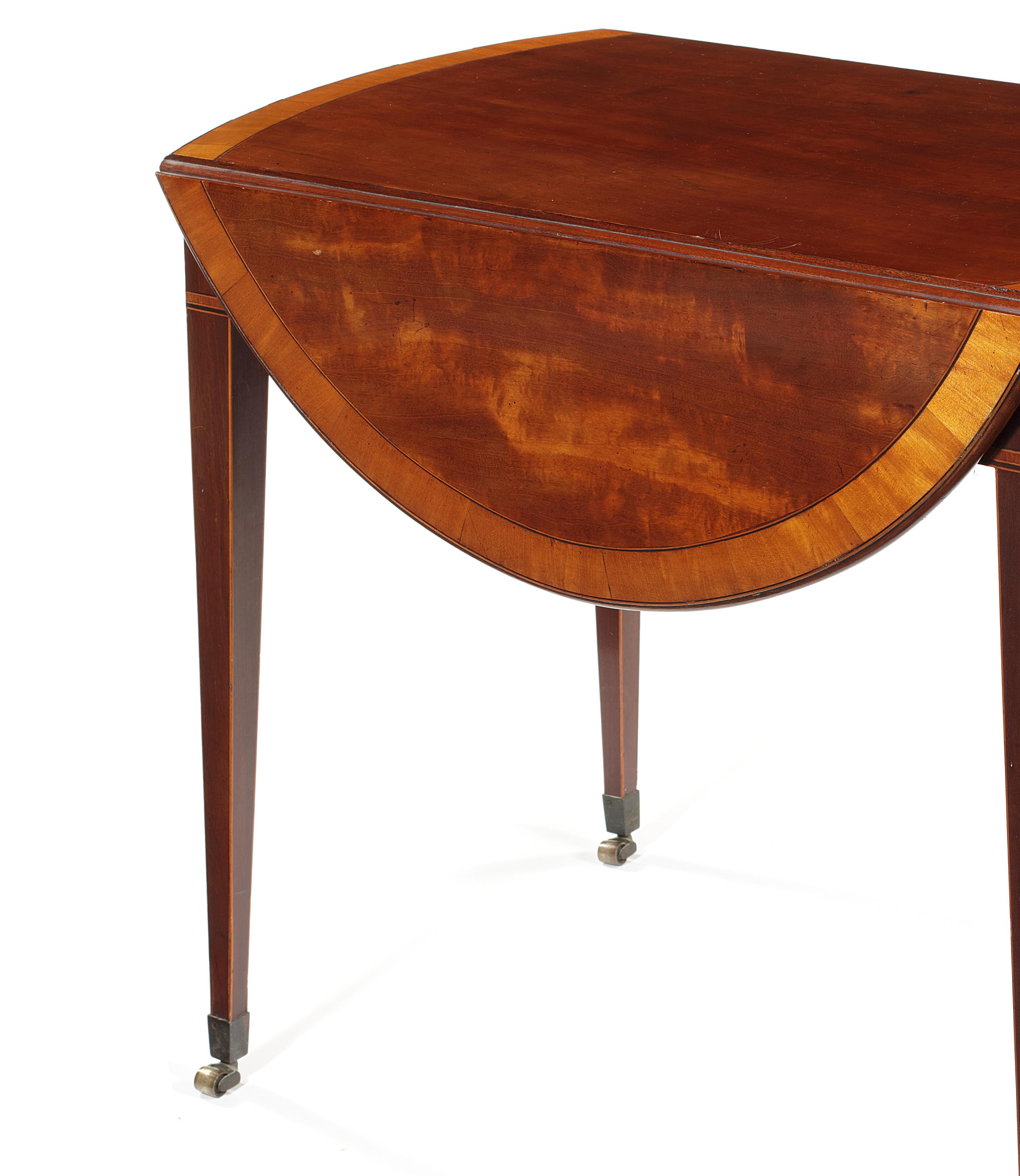 A George III mahogany and satinwood and rosewood banded Pembroke table
Inlaid with boxwood and ebonized lines, the rounded rectangular molded top above a bowed frieze drawer flanked by inlaid ovals with opposing simulated drawer on square tapering
