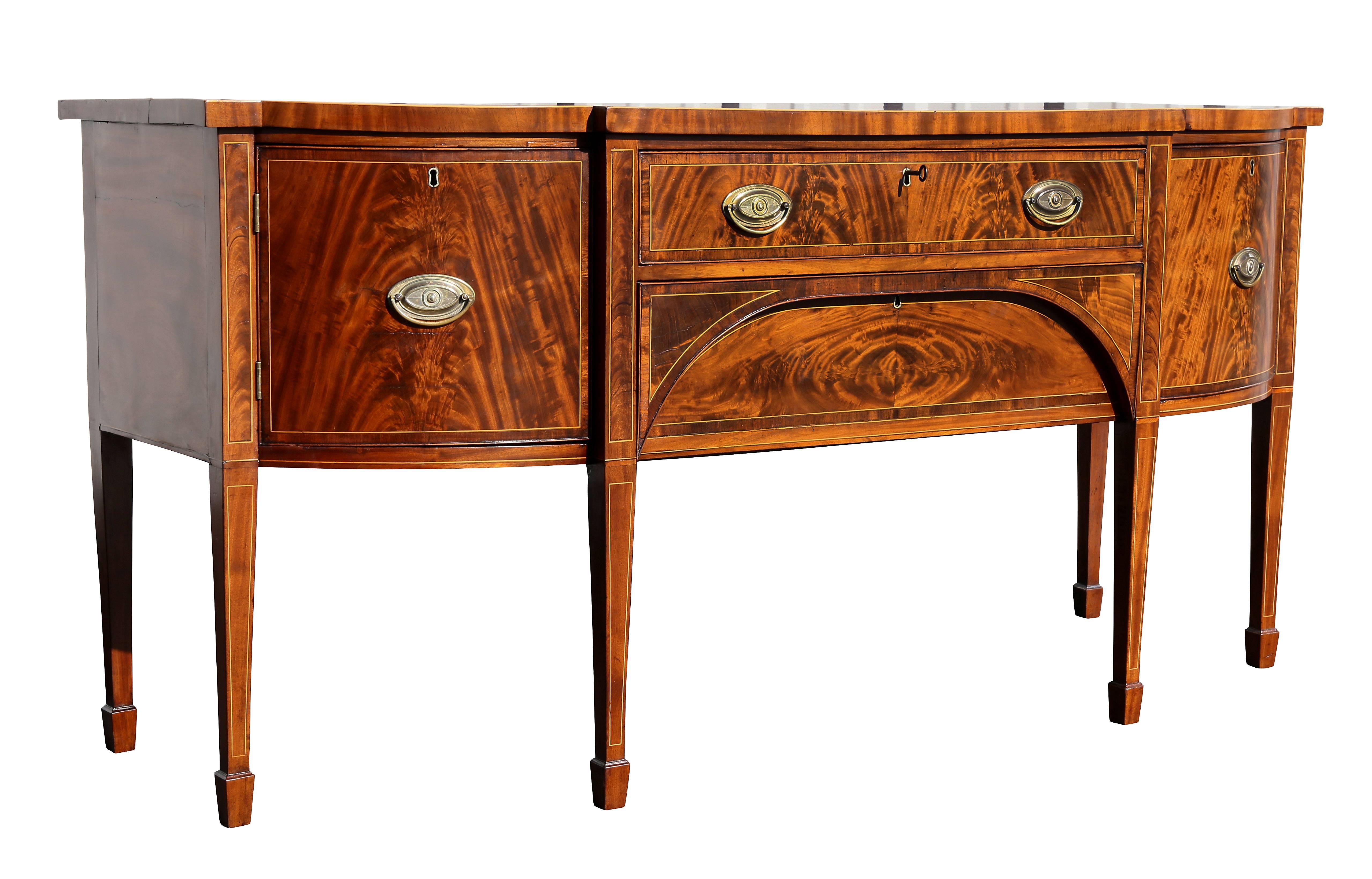 With shaped bowed top over a central drawer over a hidden frieze drawer flanked by drawers and raised on square tapered legs with spade feet.