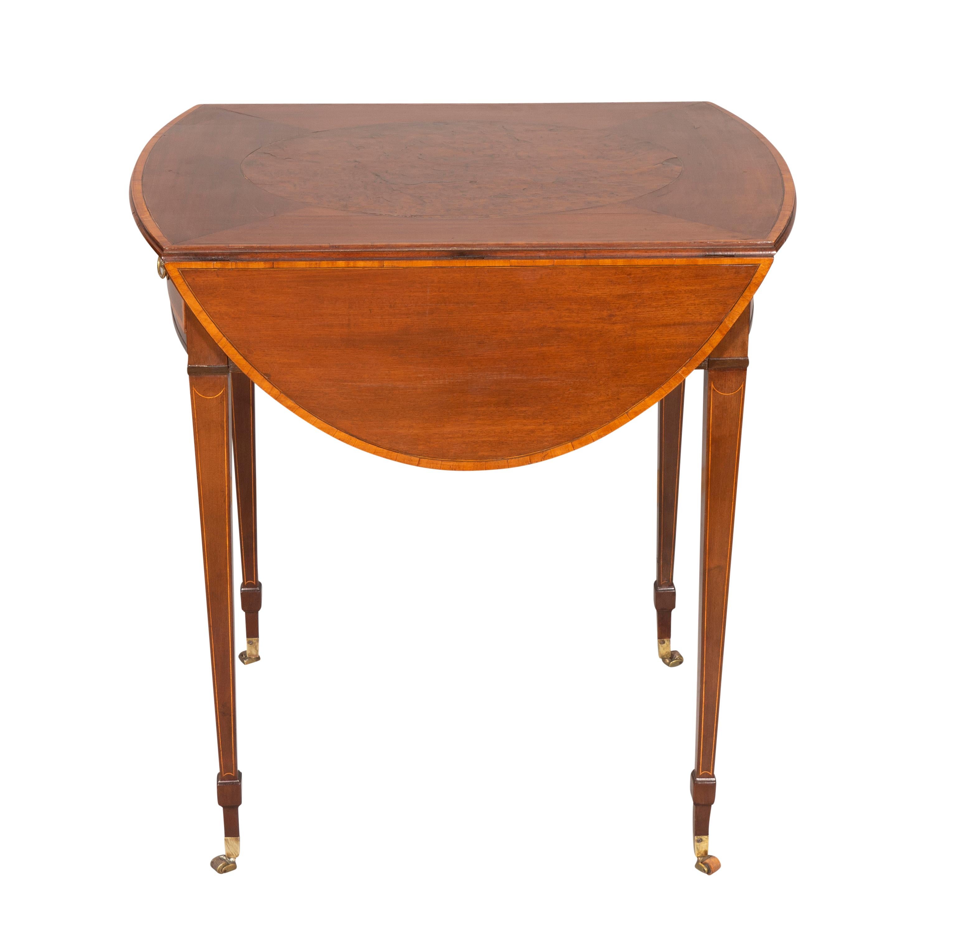 The top with oval thuya wood inlaid panel, satinwood banded edge and D shaped drop leaves, the frieze with a drawer with brass handles, raised on square tapered legs and casters.