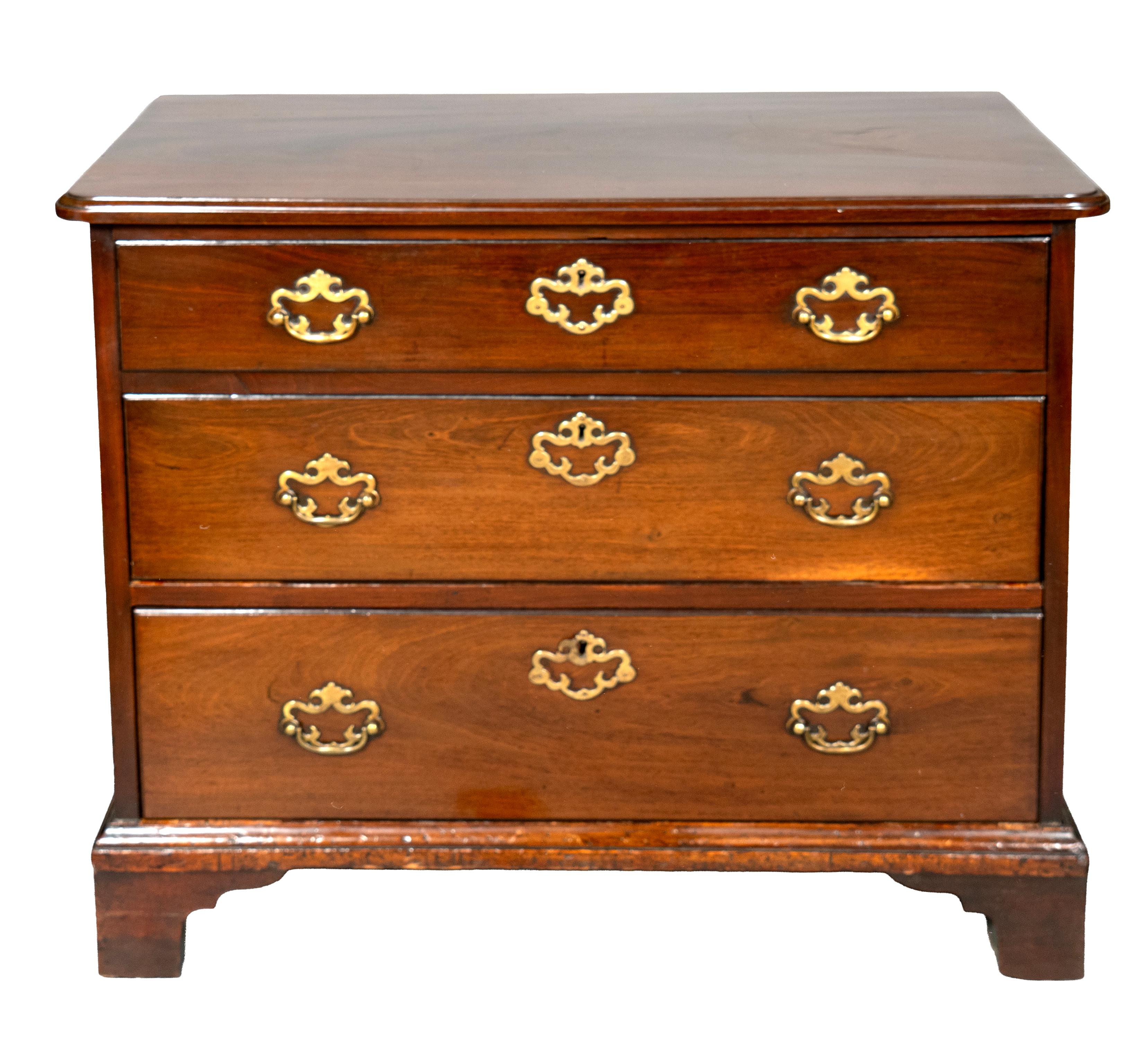 With a rectangular top with molded edge and rounded corners over three graduated drawers. Bracket feet.