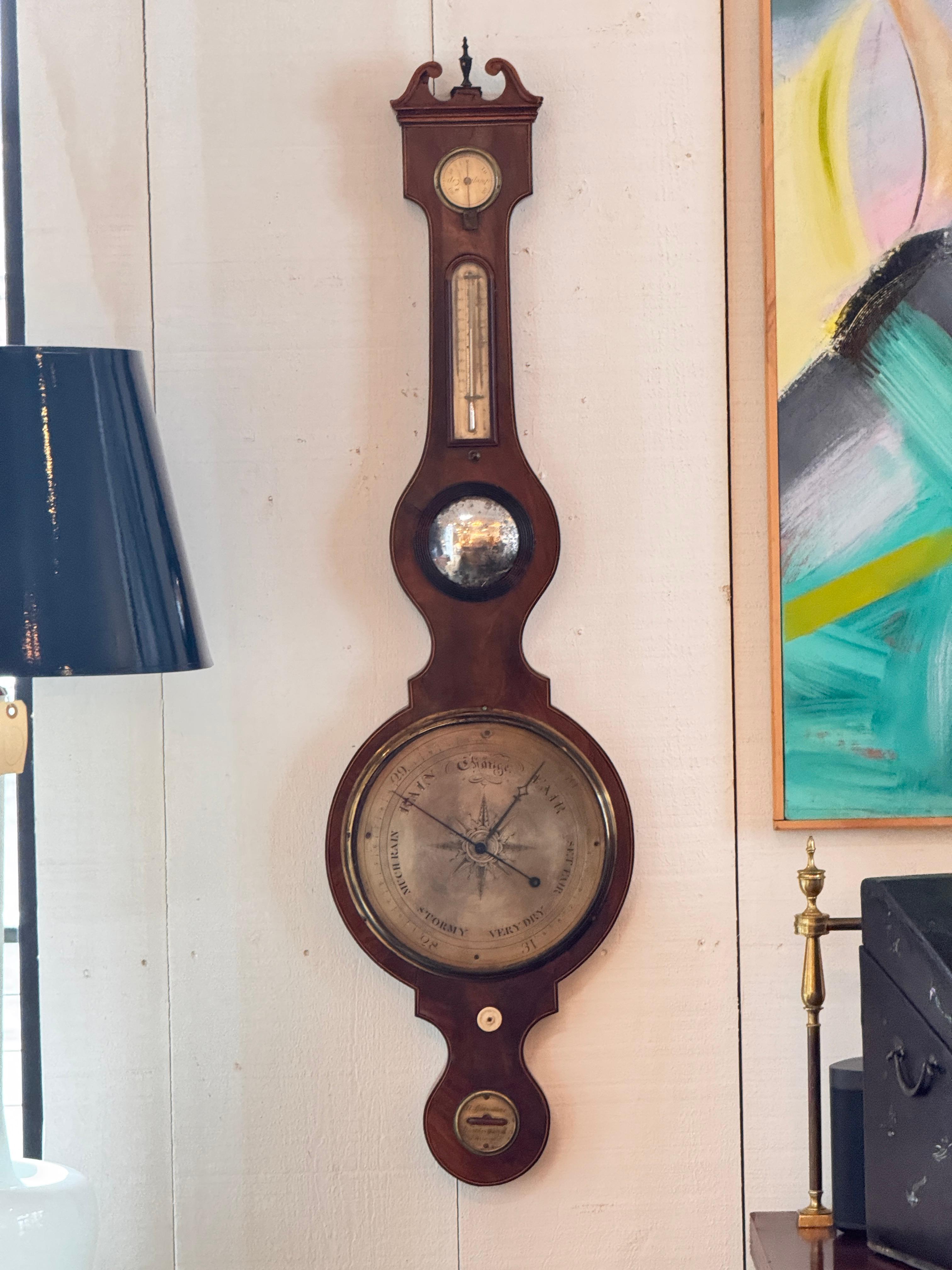 Mahogany wheel barometer with a swan-neck pediment, brass dial, thermometer, hygrometer, and level, with engraved details and age-consistent wear visible in the close-up images.
