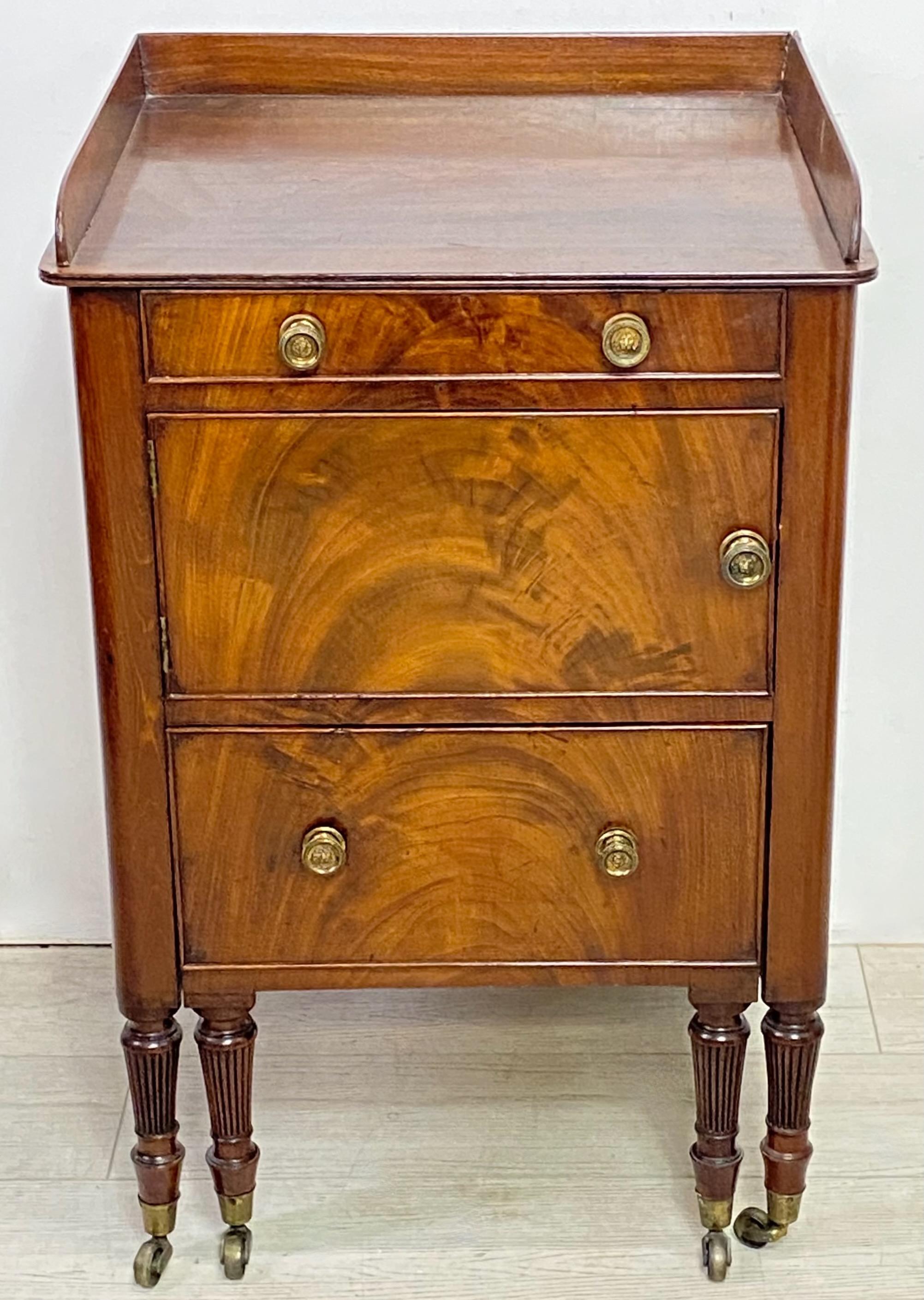 Exceptional solid mahogany bedside cabinet with flame mahogany veneer on the drawer and door fronts. Having its original finish and hardware, the commode drawer now converted to a shallow drawer.    
High quality and in very good condition.
England,