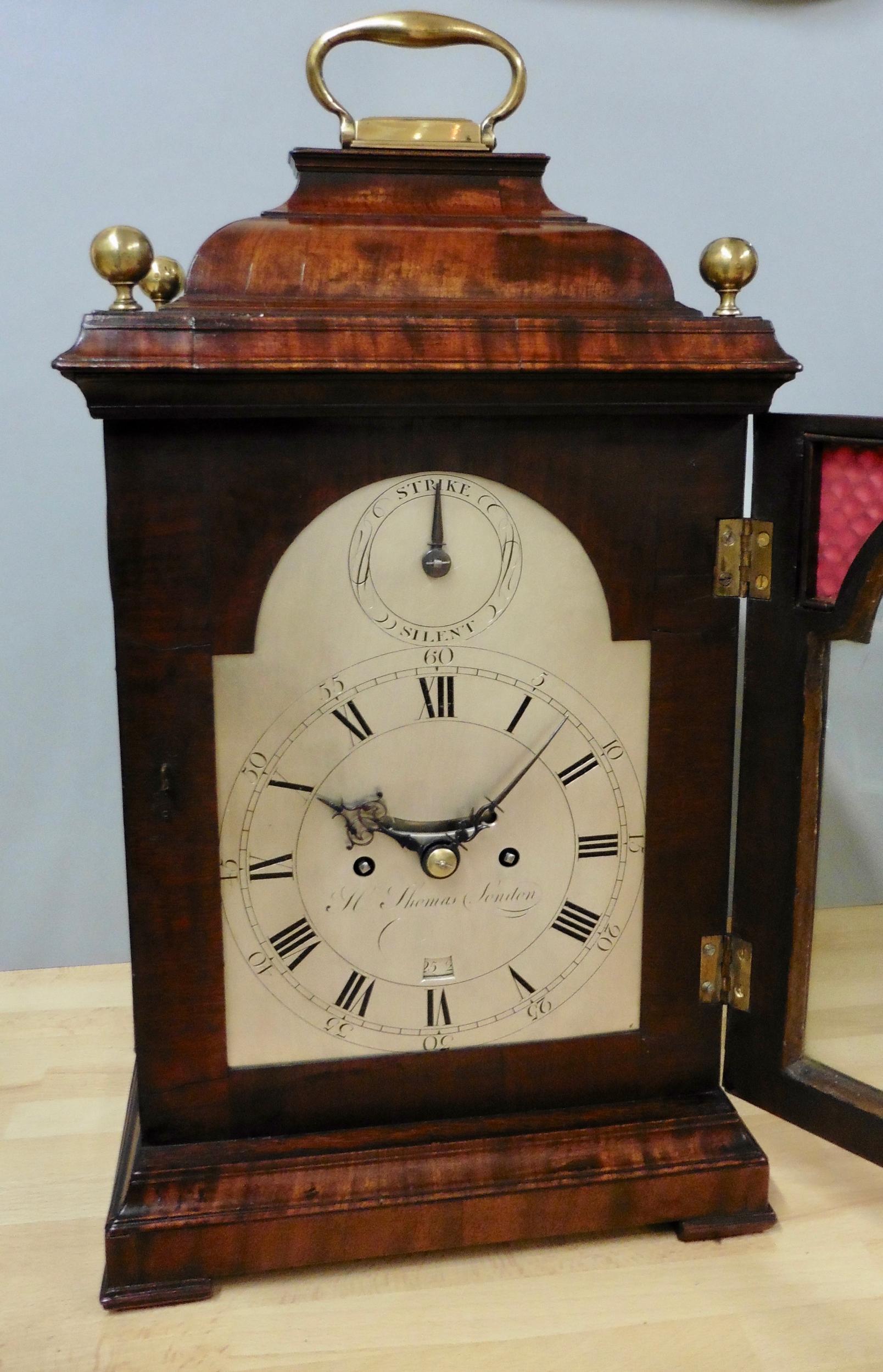 George III bracket clock by H.Thomas, London

Mahogany bell top case surmounted with hinged carrying handle and four brass ball finials standing on a raised plinth and resting on four pad feet. Cast brass quadrant, glazed side windows and roundels