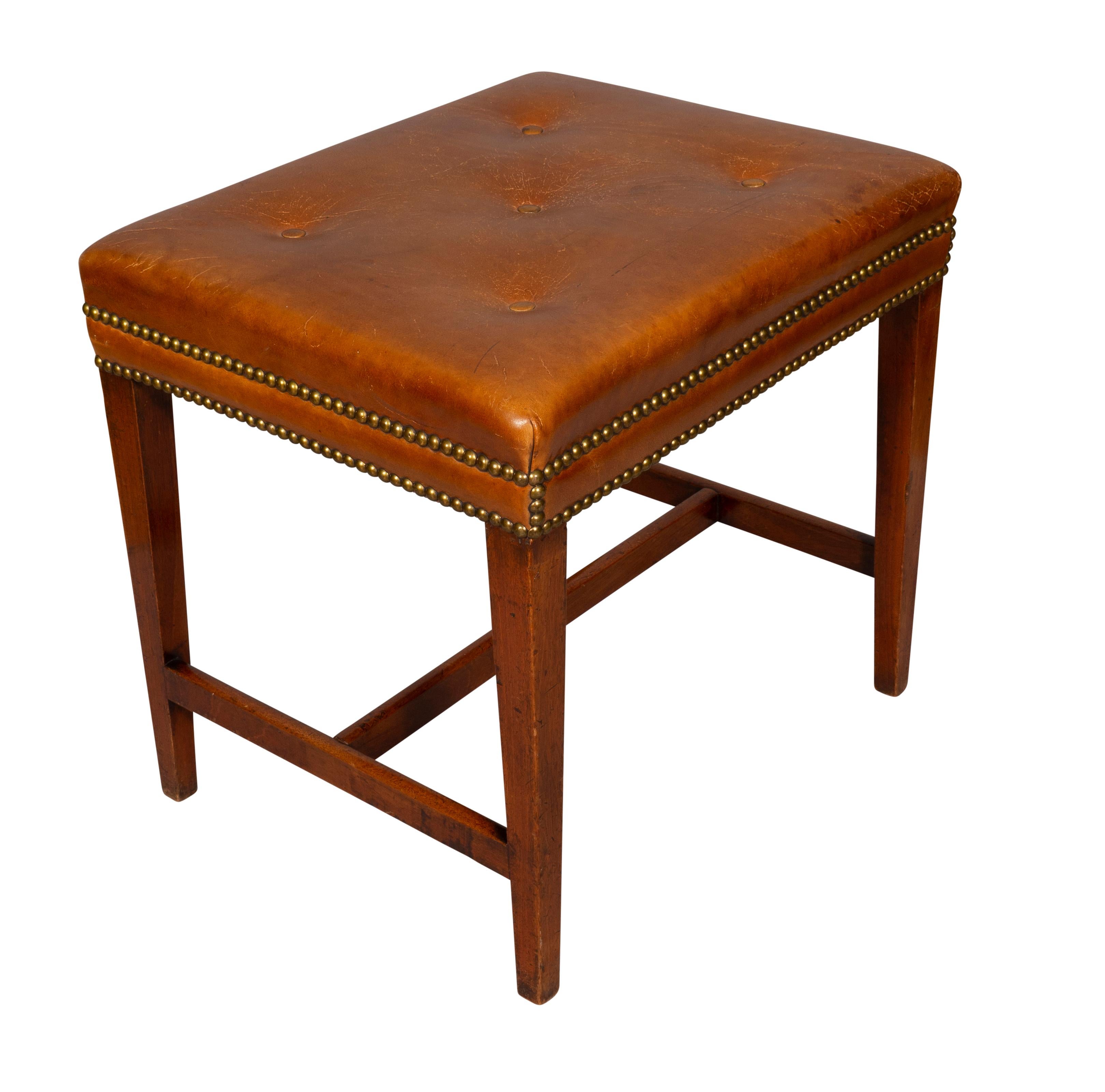 Rectangular top with brown leather and brass tacking raised on square tapered legs with H form stretchers. Estate of Douglas S. Kramer. Art collector and TV producer.