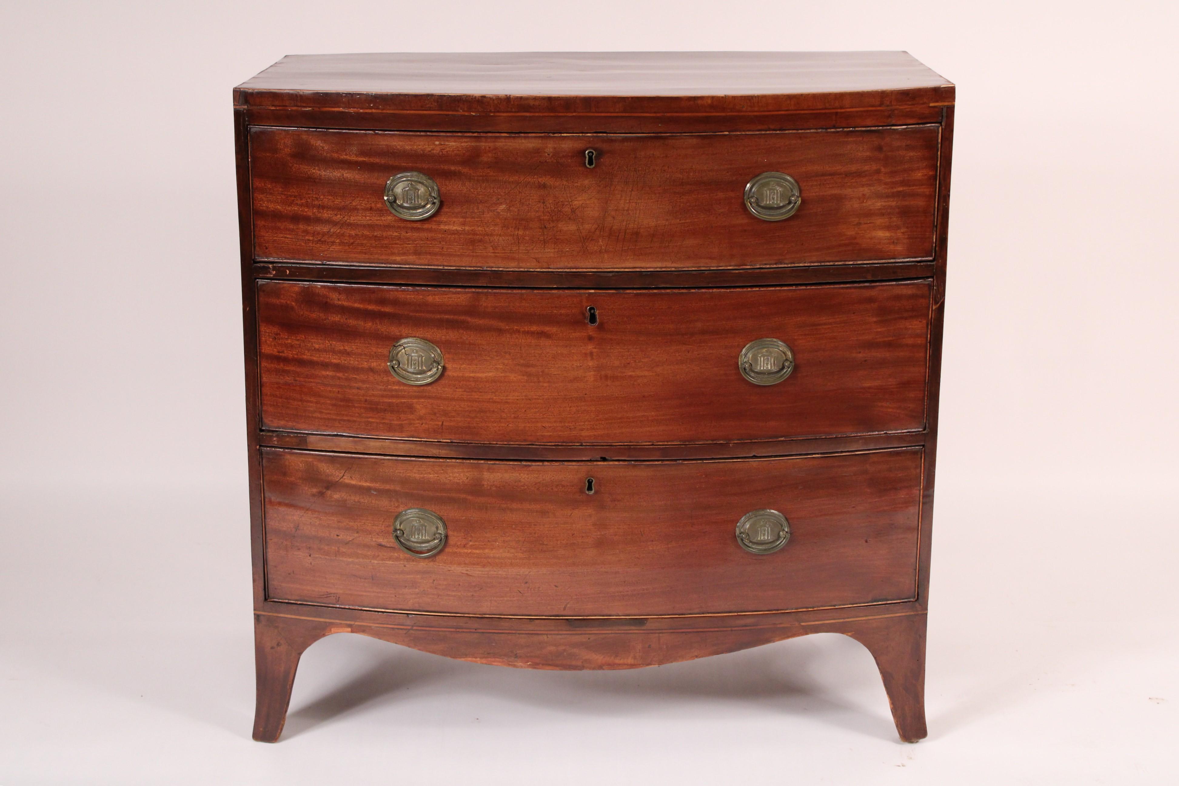 George III mahogany bow front chest of drawers, early 19th century. With a D shaped mahogany top with stringing on front and side edges, 3 cock beaded graduated drawers with brass hardware, a shaped apron, resting on splayed feet. Hand dove tailed