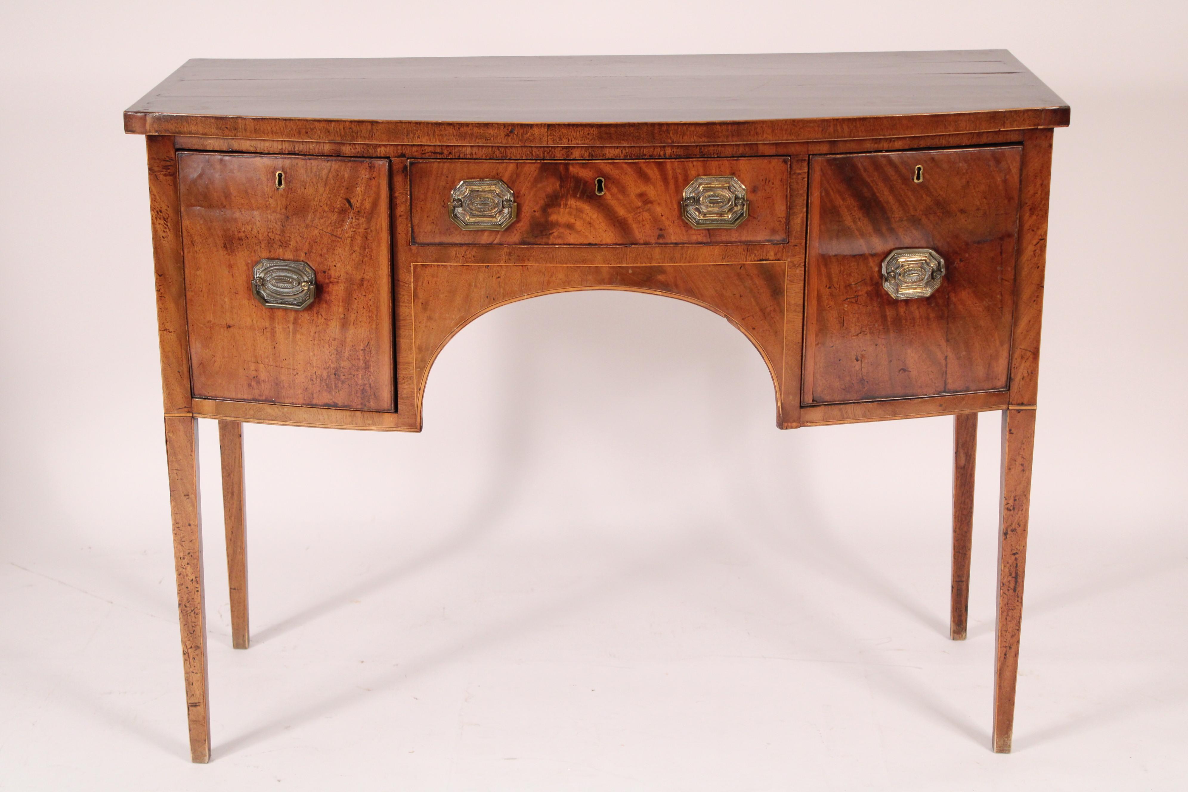 George III mahogany bow front sideboard / server, circa 1800. With a D shaped top with string inlay on front and sides edges, the frieze with 3 drawers with brass hardware, resting on square tapered legs. Nicely figured mahogany and hand dovetailed
