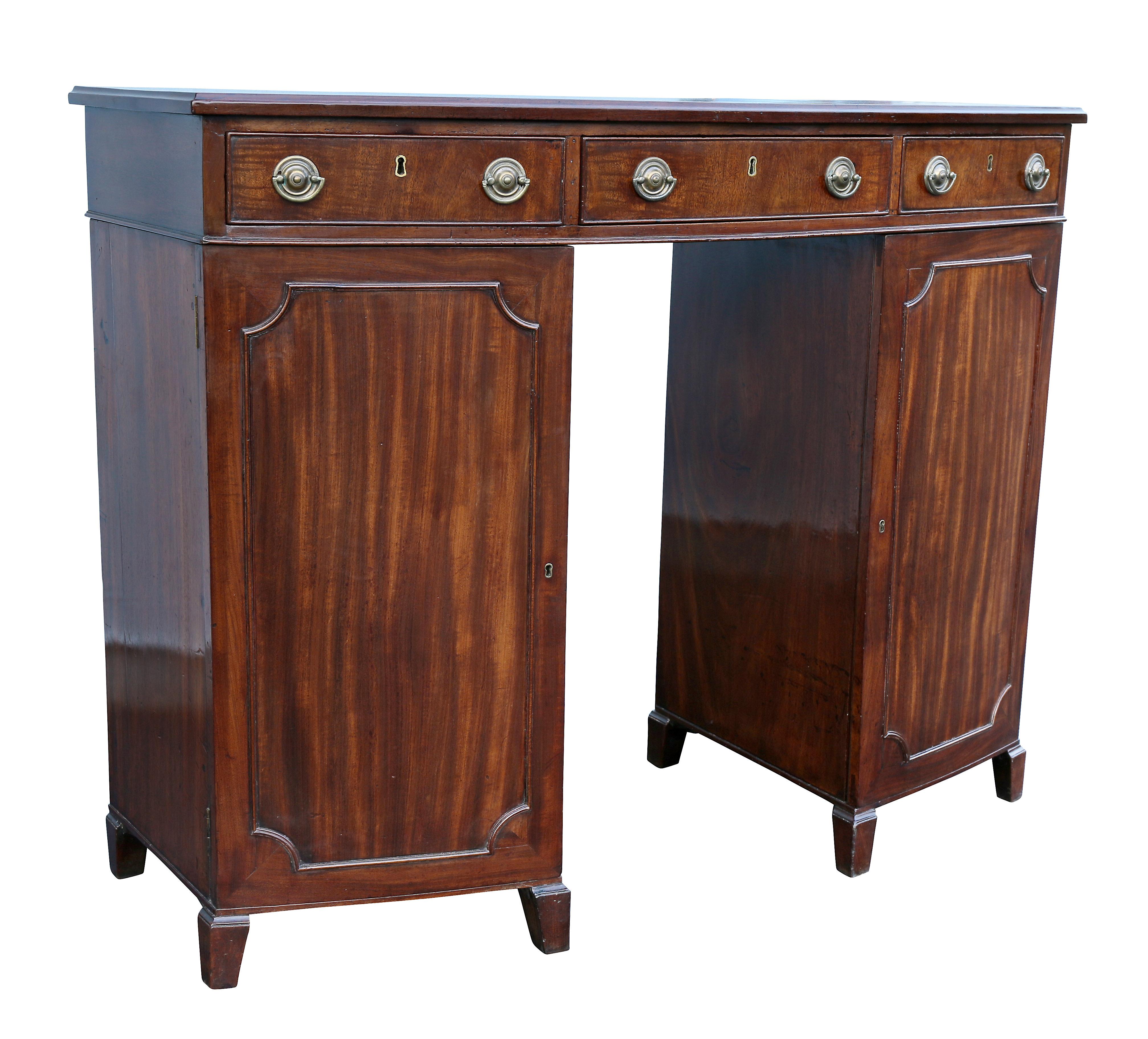 With bowed rectangular top over a conforming case with three drawers and a pair of cabinet doors raised on splayed feet. With oval brasses and key.