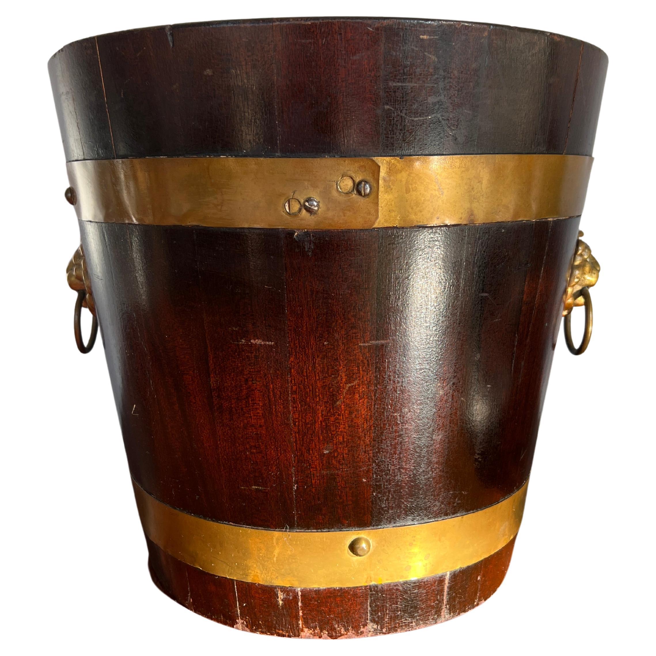 Continental, likely English.

A George III circa 1800 peat, turf, coal or kindling bucket of round form and confirming body mounted with brass straps and lion form handles. Works great against a fireplace or repurposed as a waste bin.