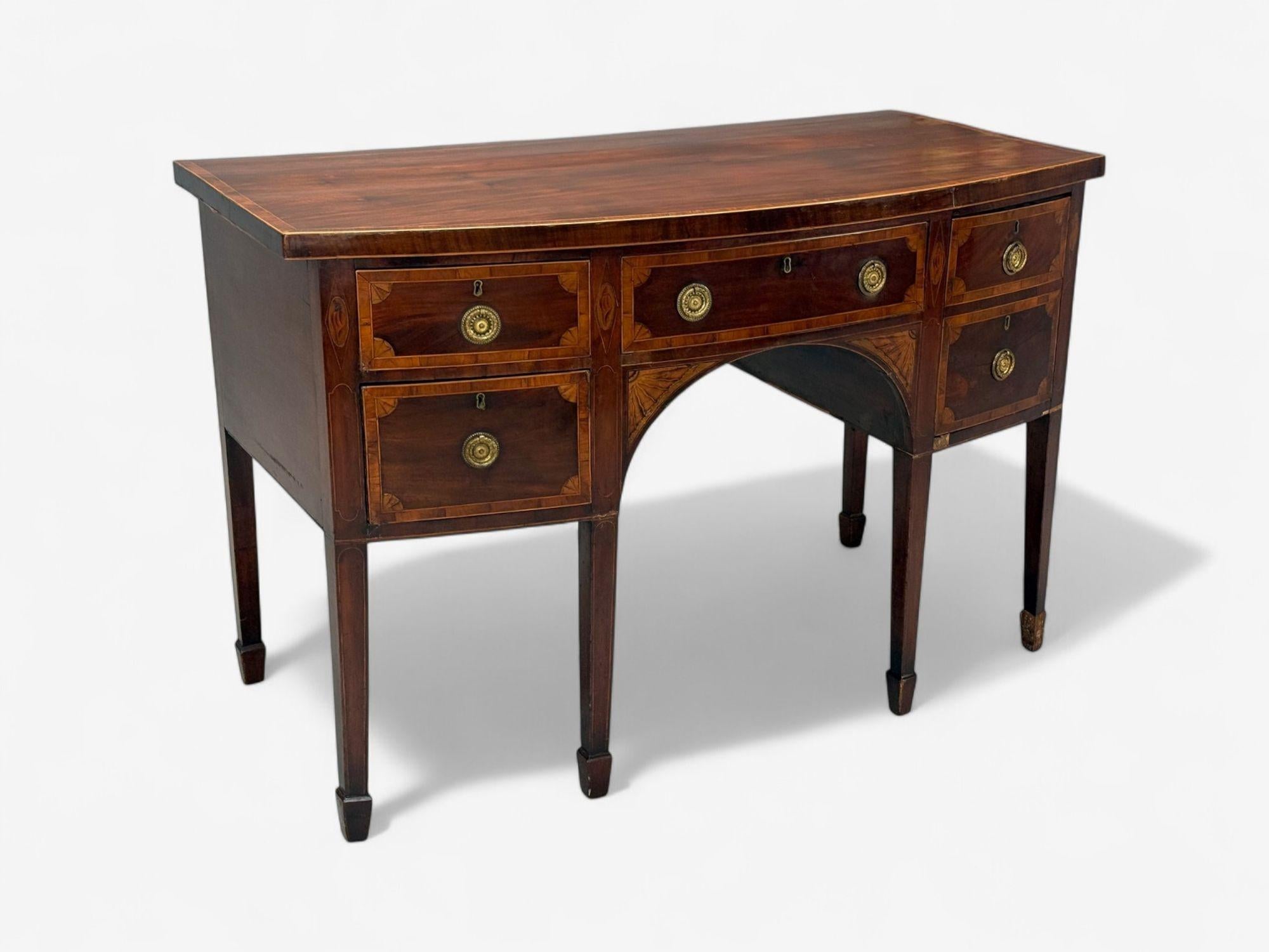 Georgian Style, Mahogany, Brass, Sideboard, England, Late 18th century

This late 18th century work features a finely crafted bow-front top, adorned with crossbanding and delicate stringing, sitting above a conforming case. The central drawer is