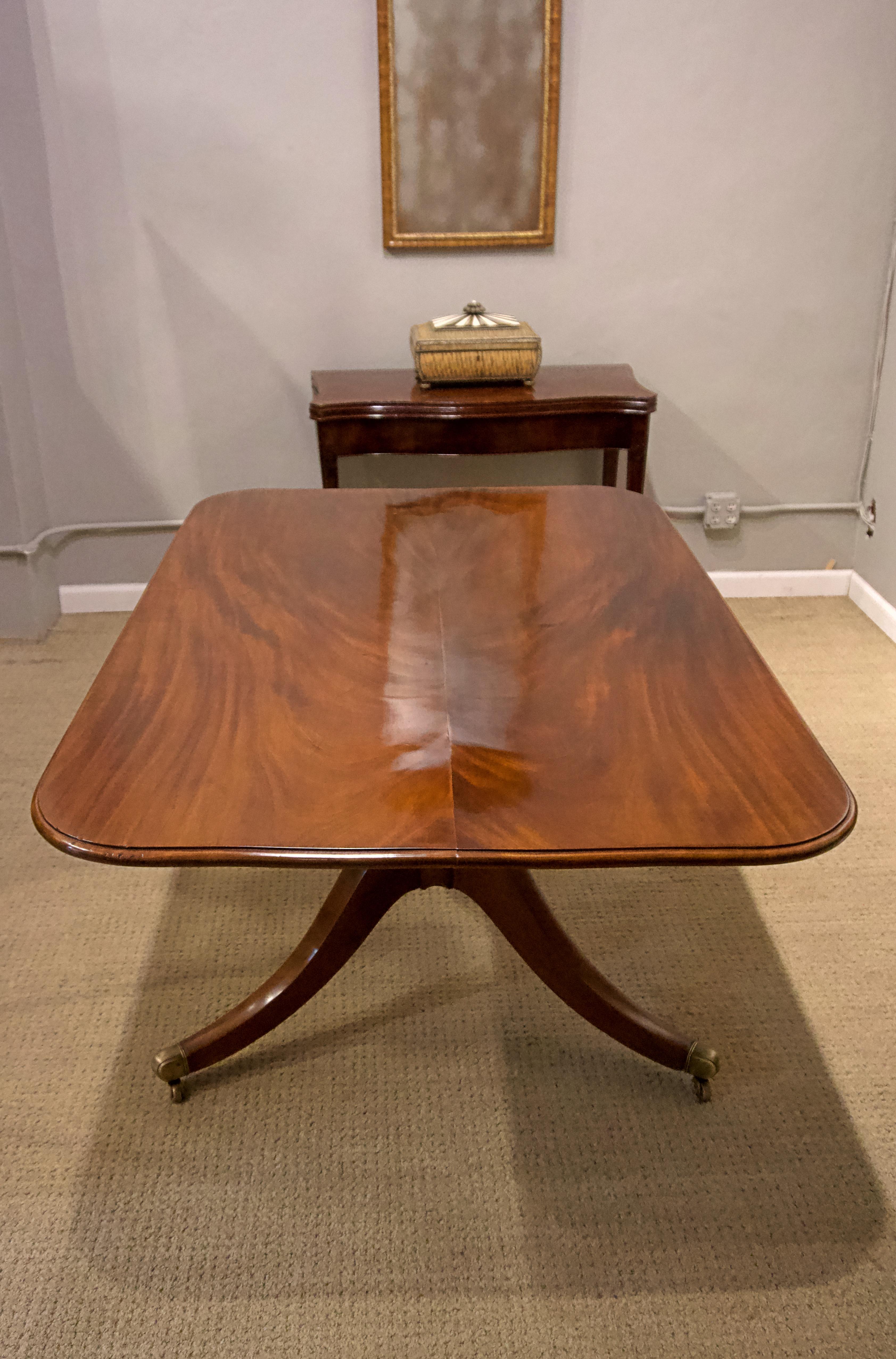 George III mahogany breakfast table with brass castors.