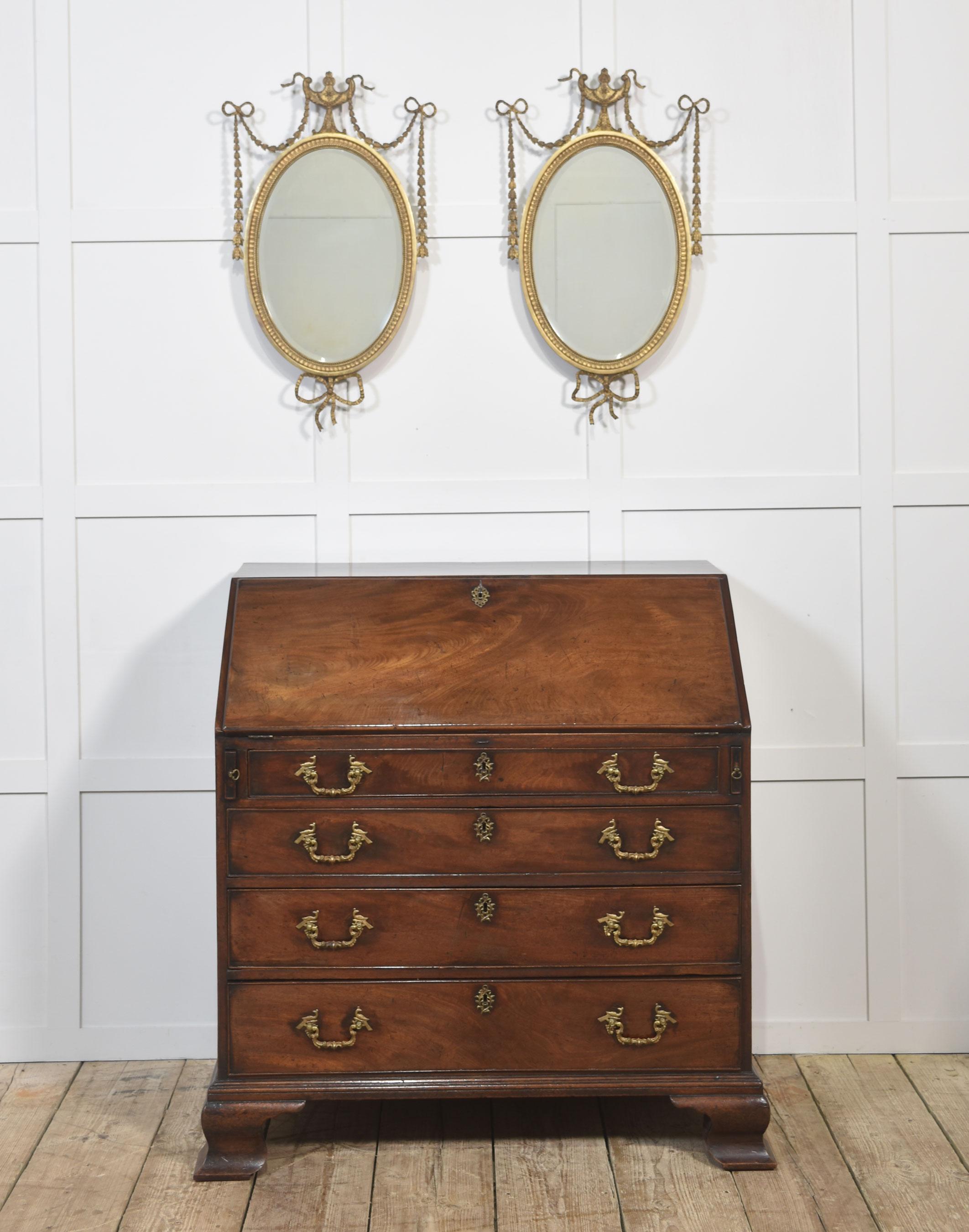 An elegant George III period mahogany bureau of fine proportions. The sloping fall front opens to reveal a well-fitted interior, complete with an arrangement of pigeonholes, small drawers, and a central cupboard, offering both charm and