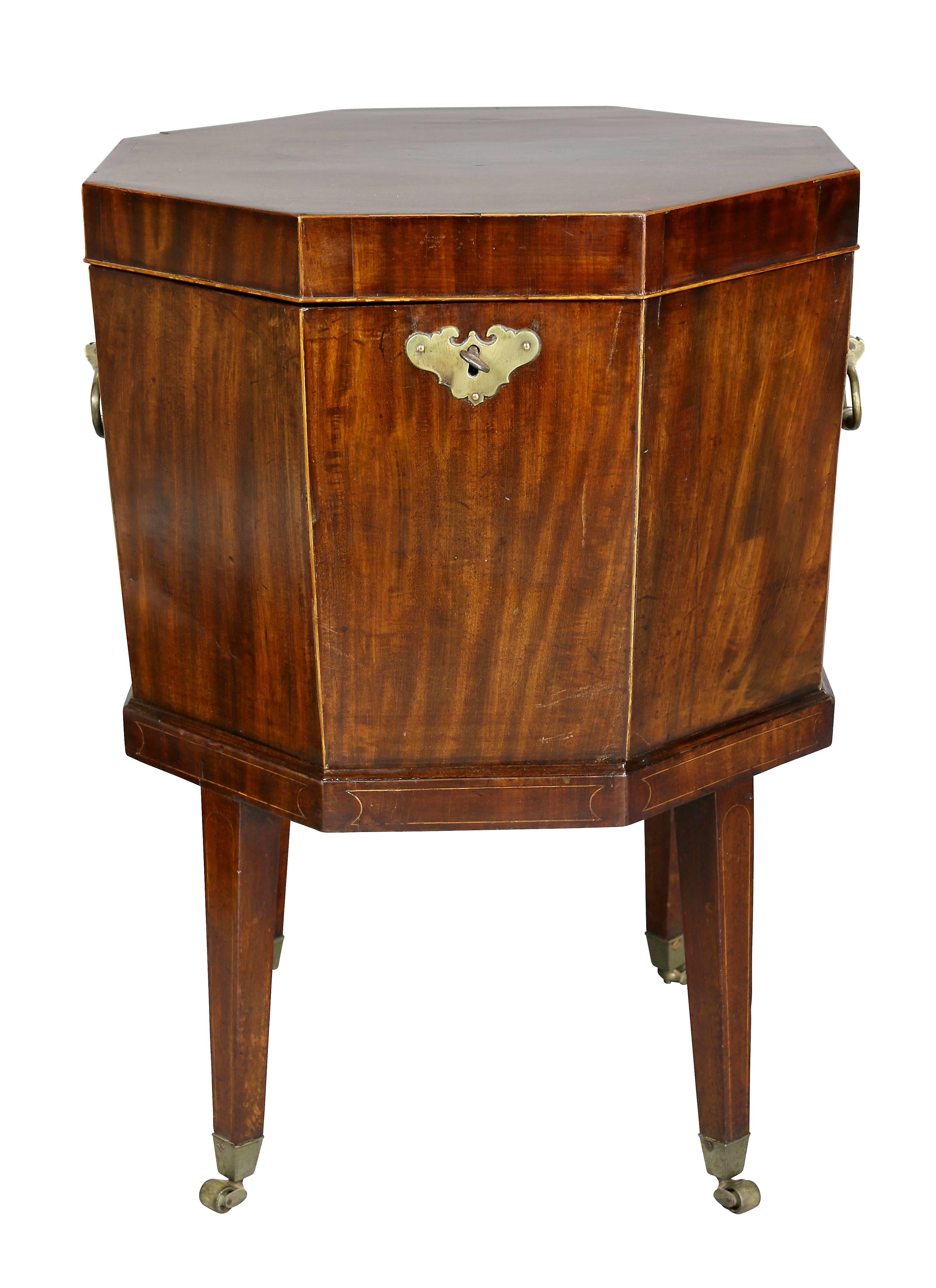 Octagonal hinged lid with conforming case raised on square tapered legs, with casters. Lacking liner.