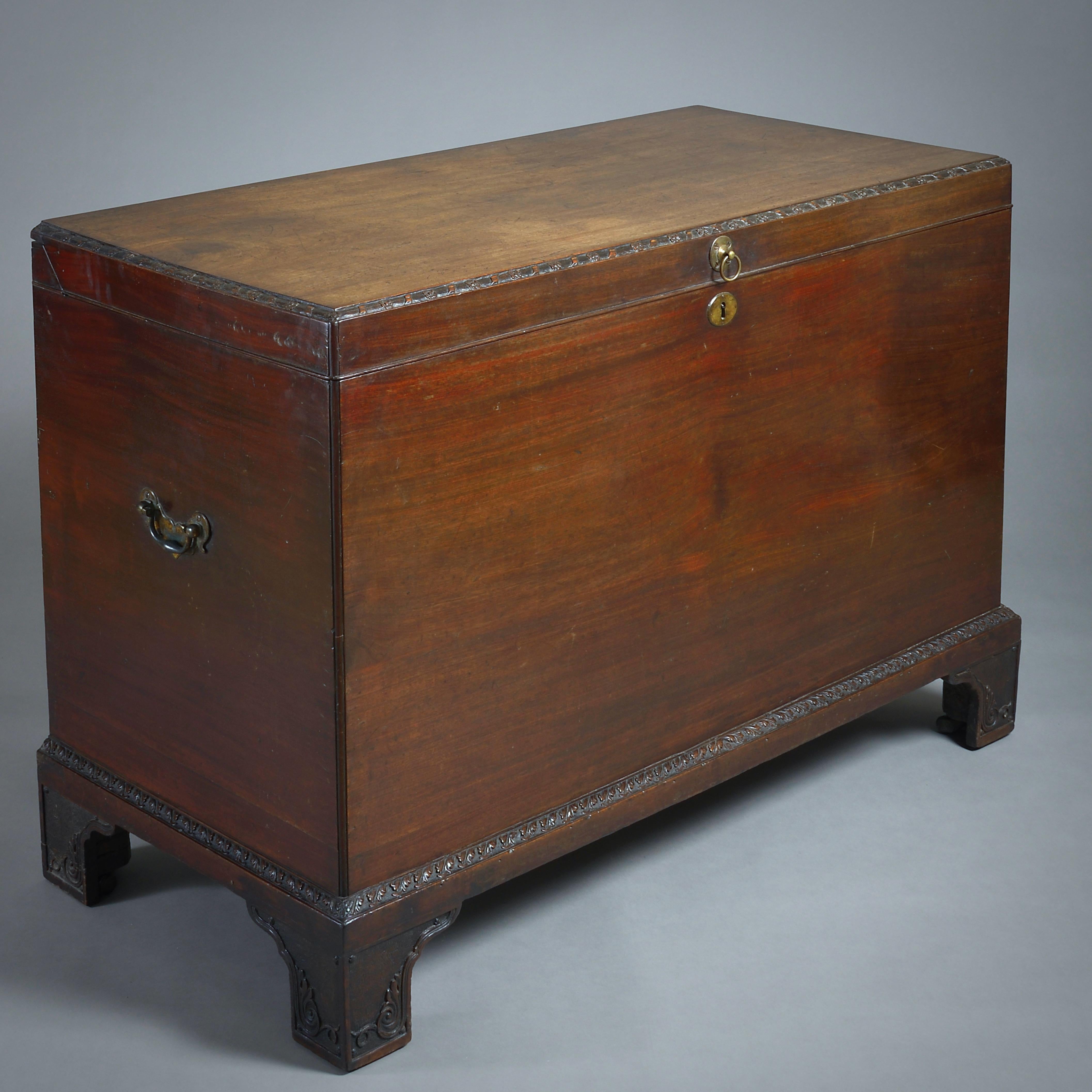 A FINE GEORGE II MAHOGANY CHEST, CIRCA 1740.

The hinged top with a ribbon and flower carved boarder. The base with a leaf-carved moulding on scroll and leaf-carved bracket feet. Original brass carrying handles.
