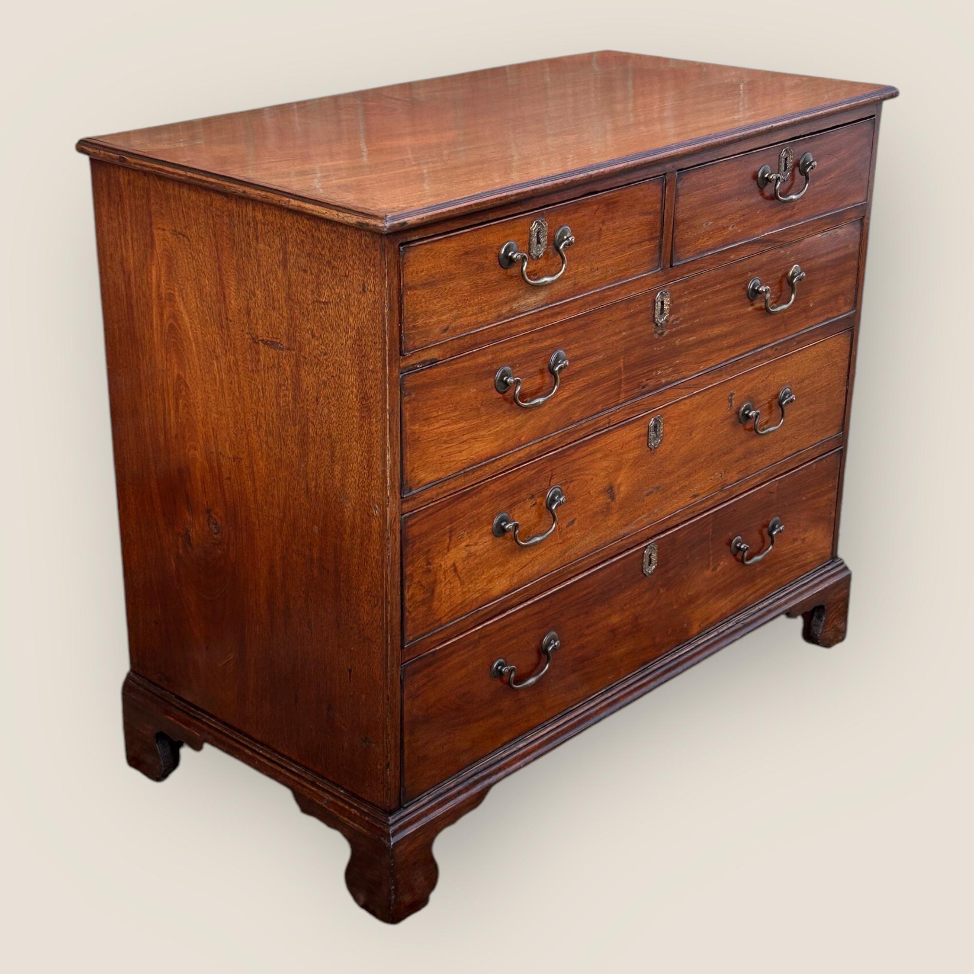 Commode George III (1760-1820) en acajou avec des tiroirs gradués en chêne et en pin. Chaque tiroir est muni d'une poignée en laiton et d'une inscription sur la clé en laiton avec des détails floraux. La commode est dotée de pieds en console et d'un