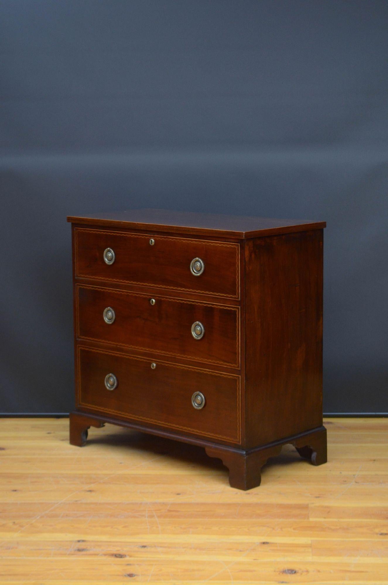 J035 Georgian mahogany and inlaid chest of drawers, having oversailing figured mahogany top with inlaid edge above three inlaid, graduated drawers fitted with brass ring handles, all standing on shaped bracket feet. This antique chest of drawers is