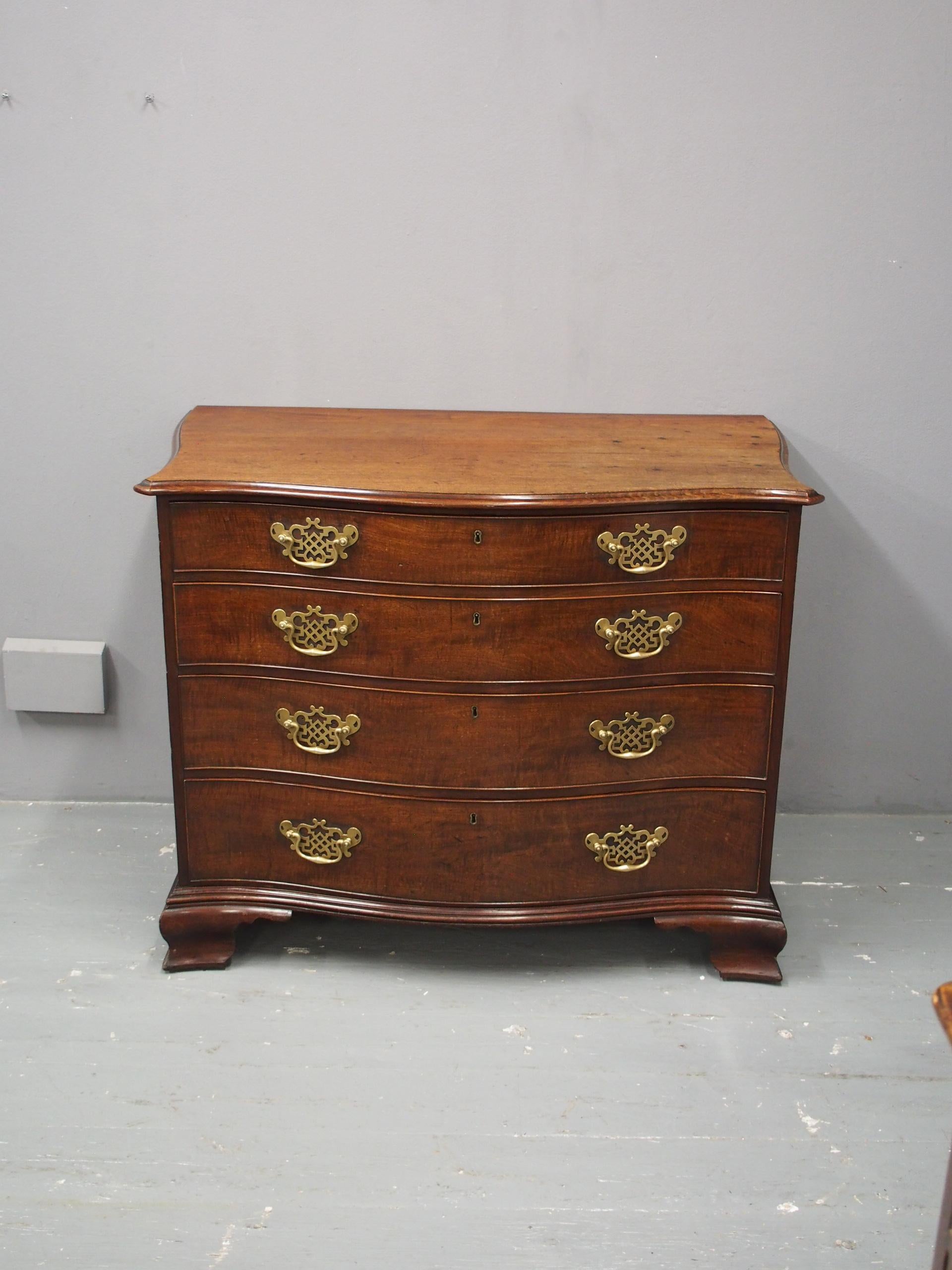 Circa 1770, George III mahogany chest of drawers or commode. The top has a serpentine front and unusually, serpentine sides in figured mahogany with moulded edges above four graduated, cock-beaded long drawers in fiddle back mahogany with