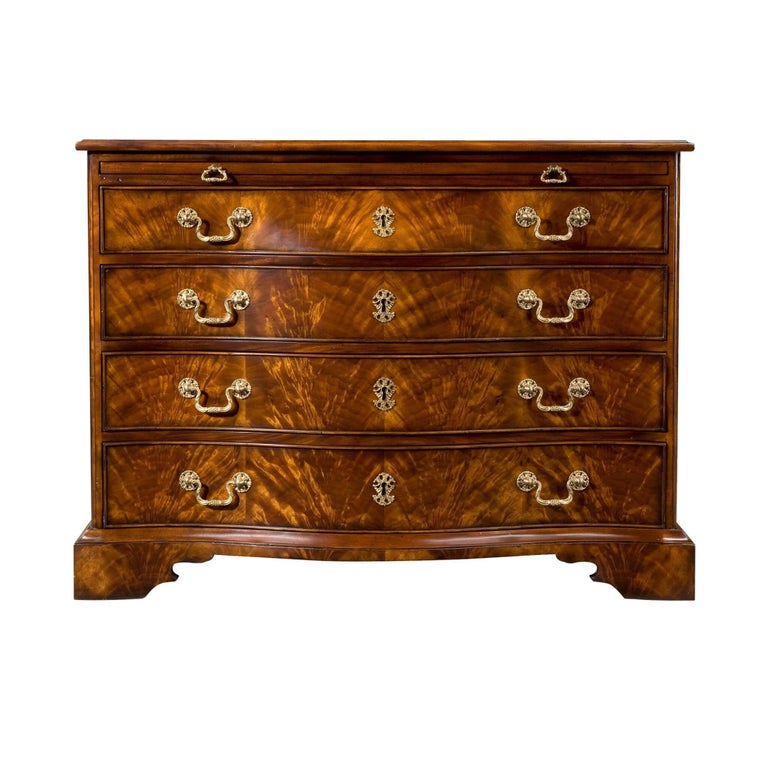 A large George III style mahogany bombe form chest of drawers, the rectangular molded edge top above a brushing slide with four shaped serpentines and graduated drawers below, applied with finely cast brass escutcheons and drop handles, on a plinth