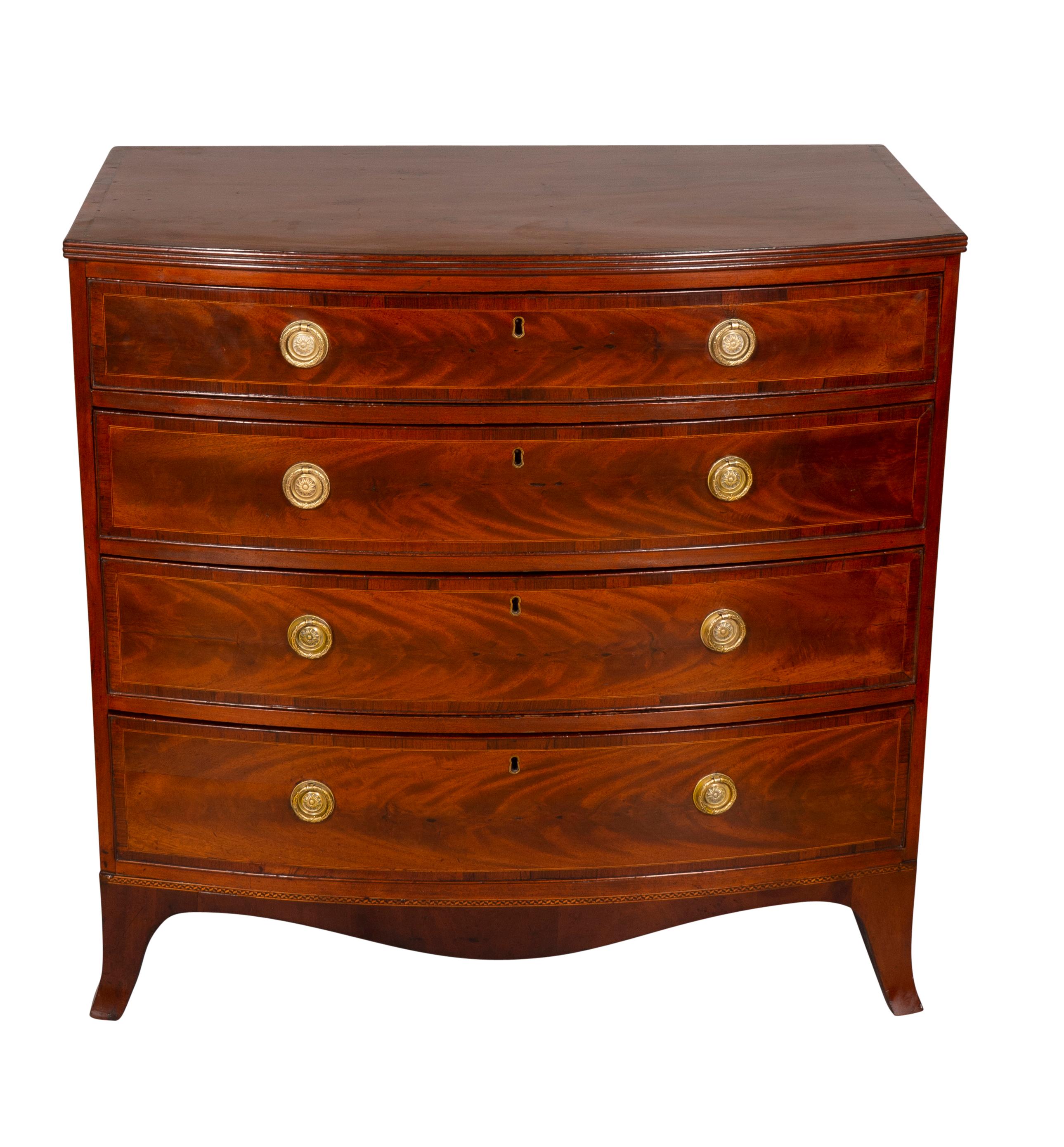 Rectangular cross banded bowed top over four graduated cross banded drawers with figured veneers, round brass handles and ending on French splayed feet.