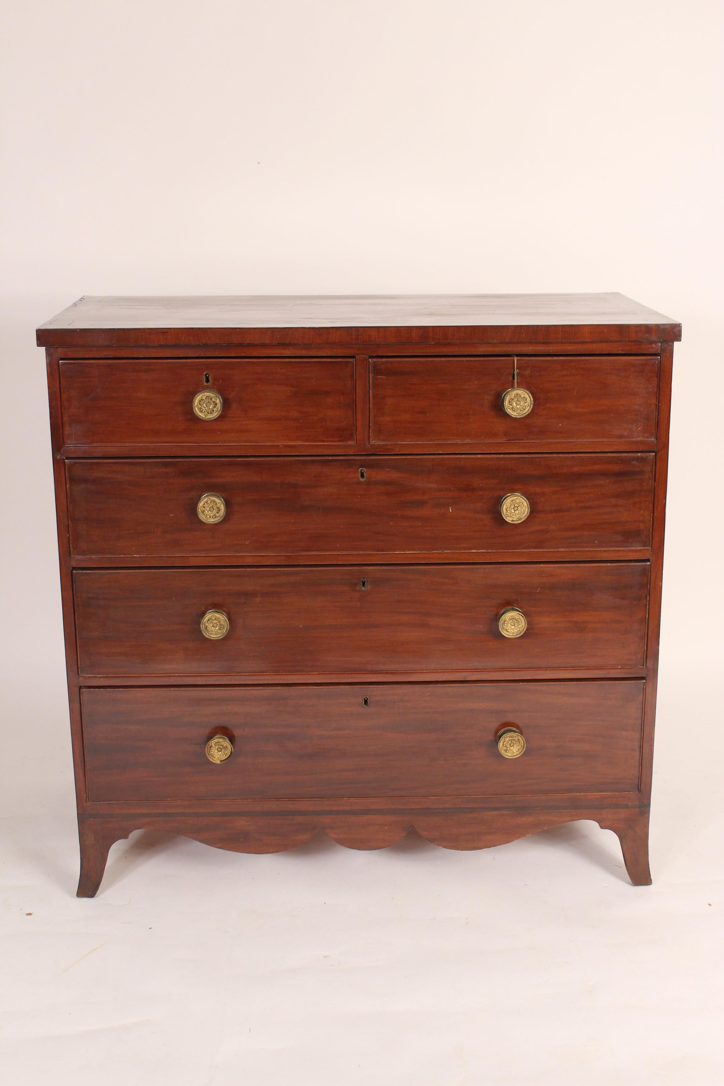 George III mahogany chest of drawers with a scalloped apron and crossbanded top, early 19th century.