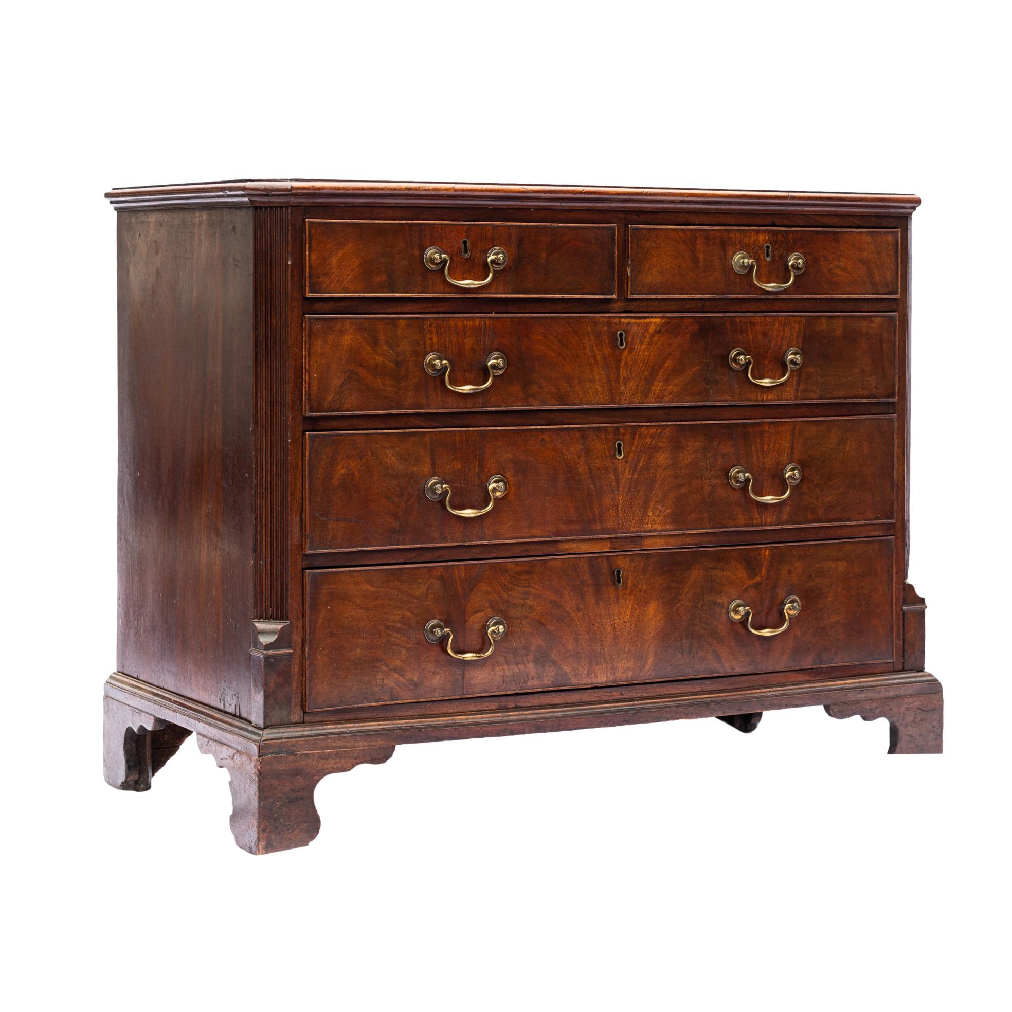 George III Mahogany Chest-of-Drawers, with a banded top, with two short drawers over three long graduated ones, each with cockbeading and oak linings, with canted and molded front corners and reeded posts, on the original ogee bracket feet, with