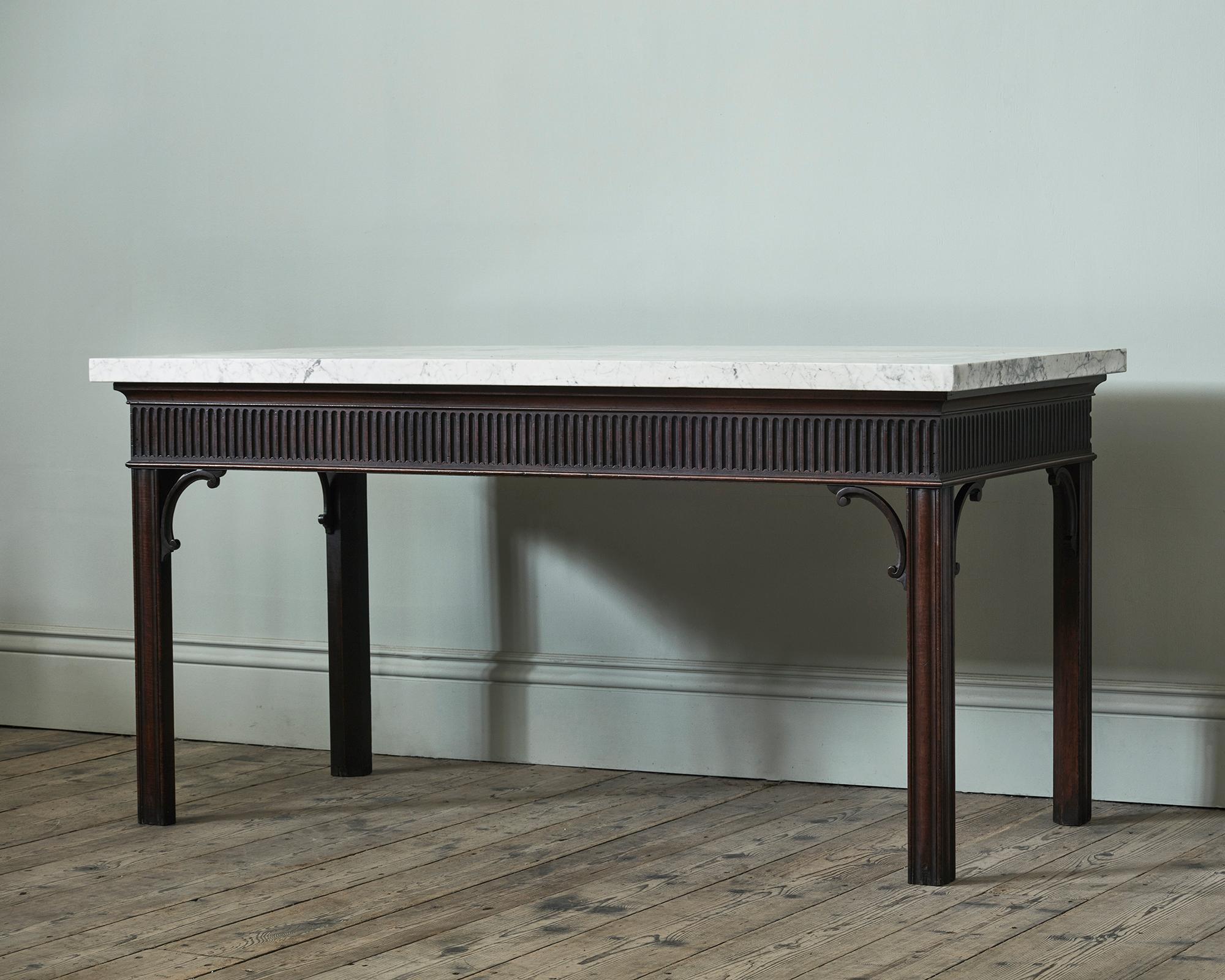 A George III Mahogany Console Table

With rich and dry surface patina, and depth of colour, with deeply carved fluted frieze and gently shaped spandrels, on square moulded legs.
With later Carrara marble top.

Additional information:
Dimensions:
