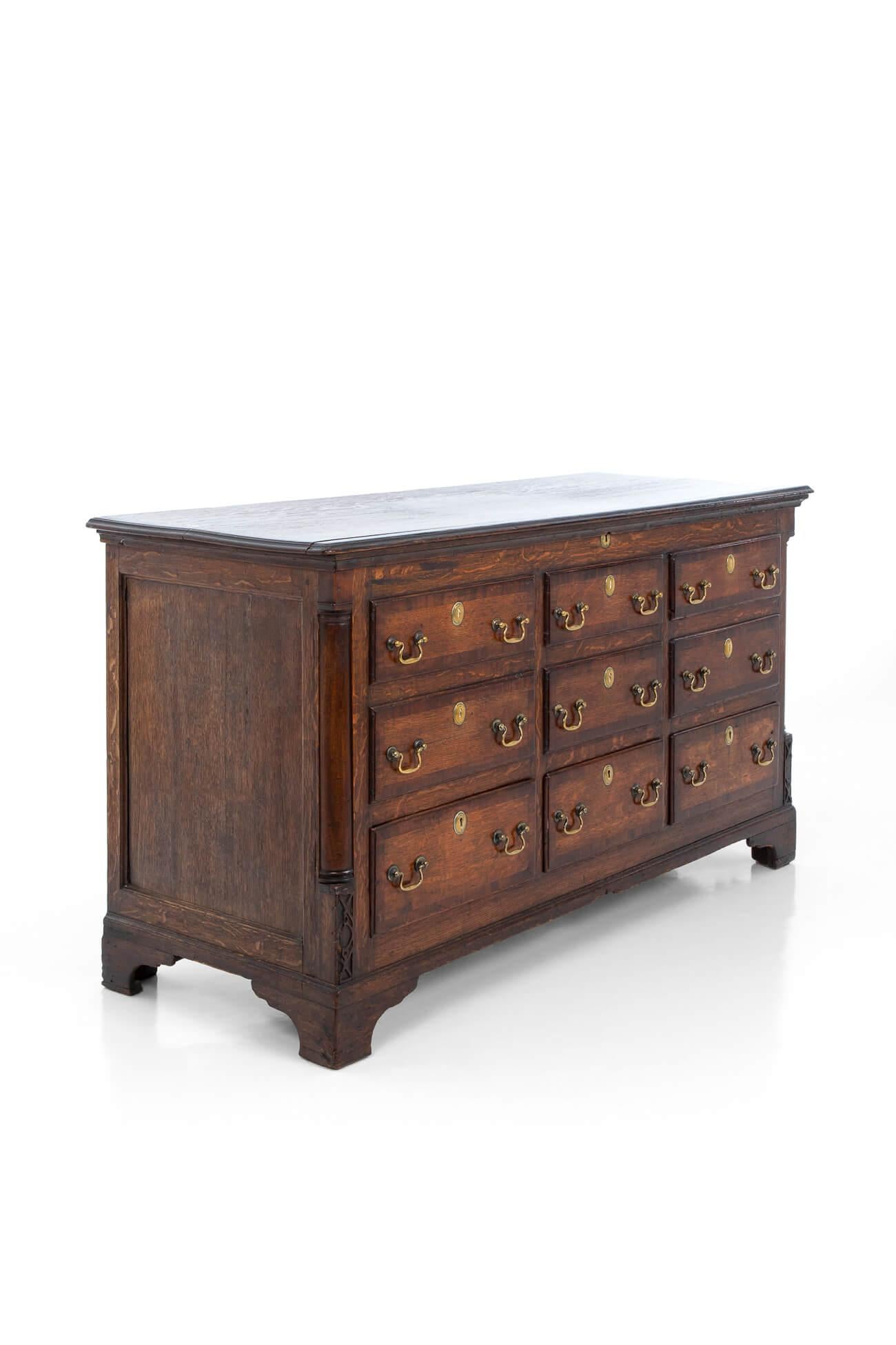 Large rectangular hinged top over a central crossbanded panel with three lower drawers and six upper faux drawers. Original brass swan neck handles and keyhole covers flanked by inset quarter columns raised on bracket feet. 
English, circa