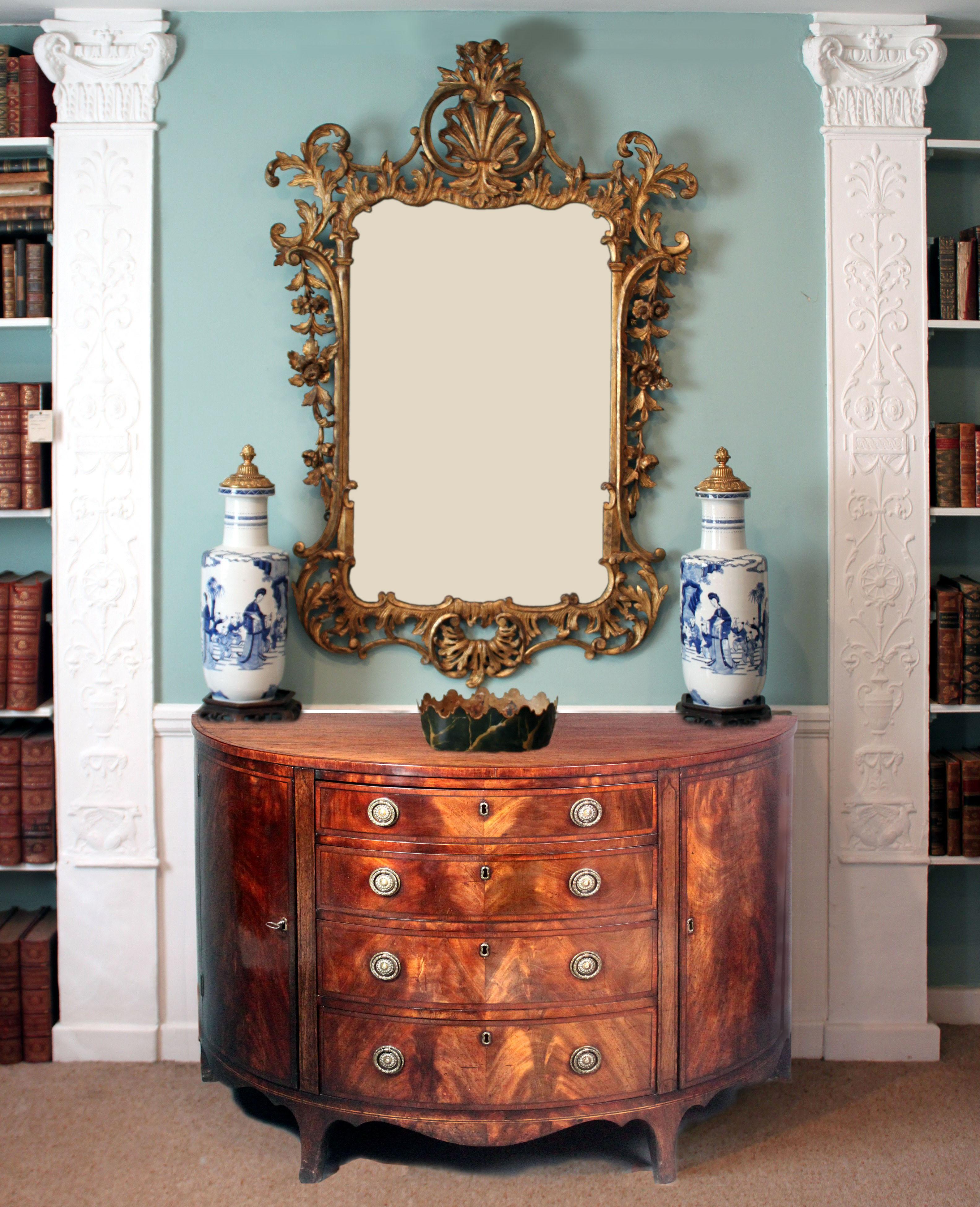 A fine George III demi-lune dining room commode in figured mahogany of a good colour and patina; extensive cross-banding in tulip-wood and stringing in boxwood and ebony. The drawers lined in oak and with finely cut dove-tailed joints. Tall elegant