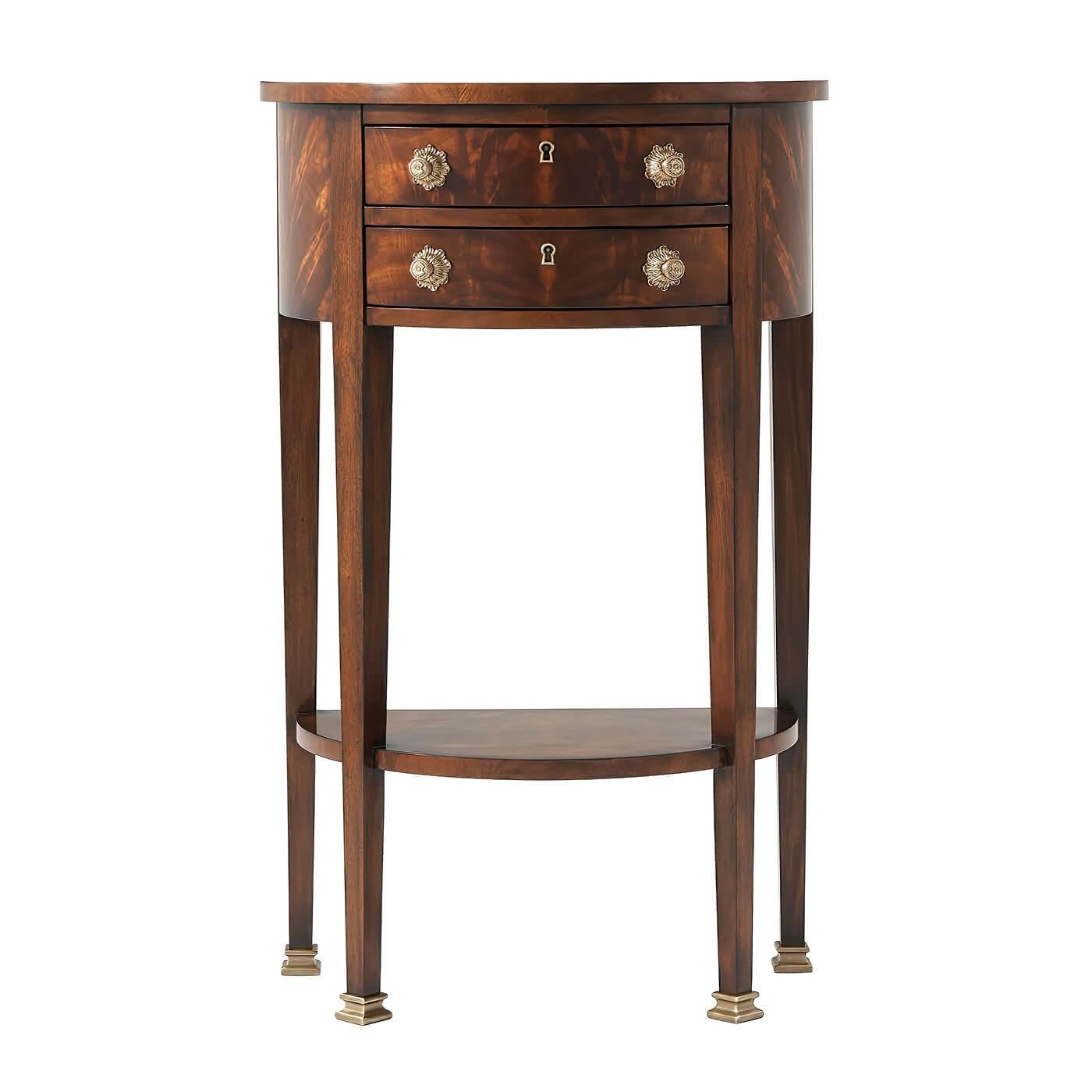 A George III style demi lune console of small proportions, fitted with two central frieze drawers applied with brass handles and locks, on square tapering legs terminating in brass feet joined by an undertier. 

Dimensions: 22