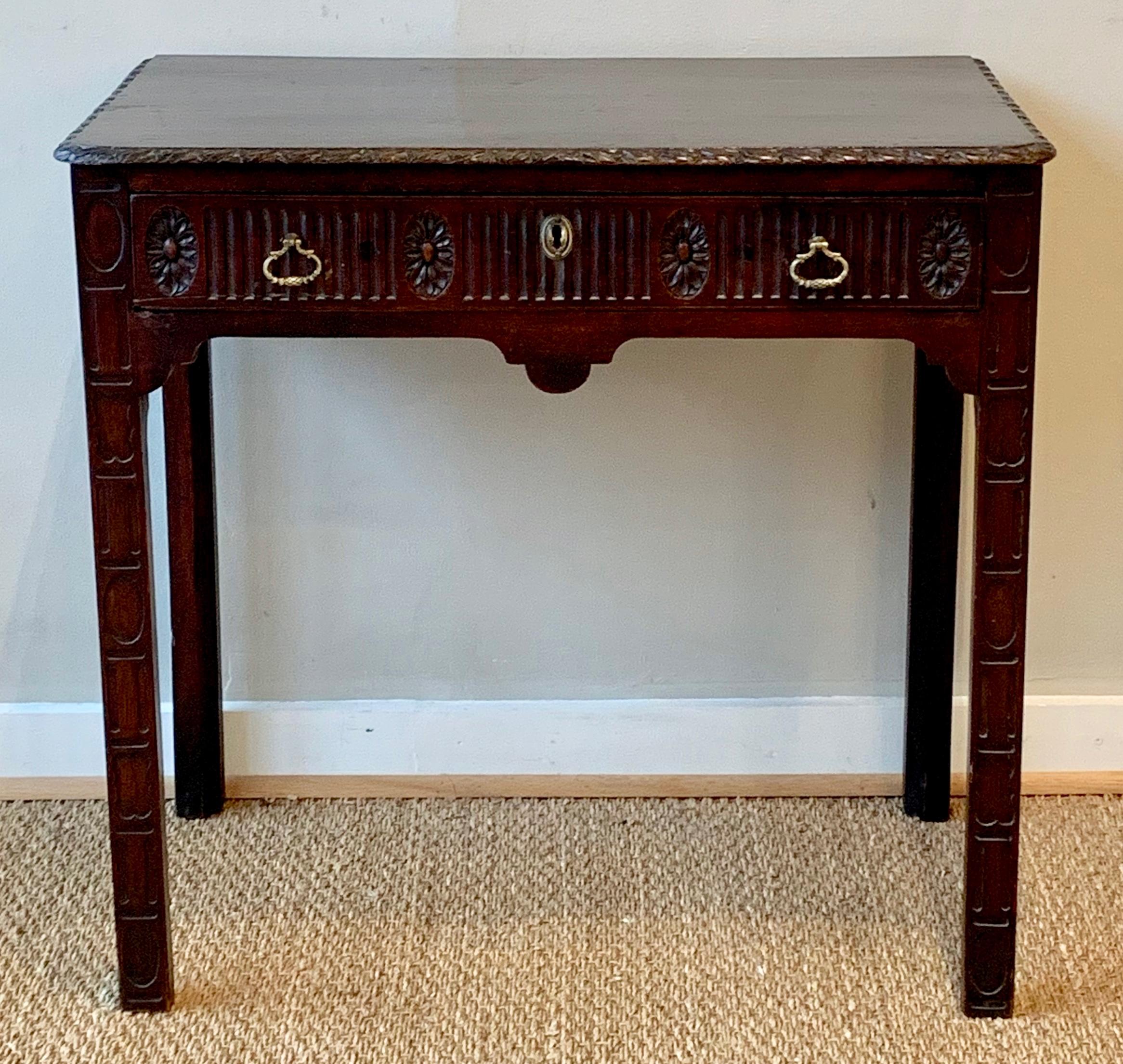 A late 18th century heavily carved mahogany single drawer console or side table with original brass pulls.