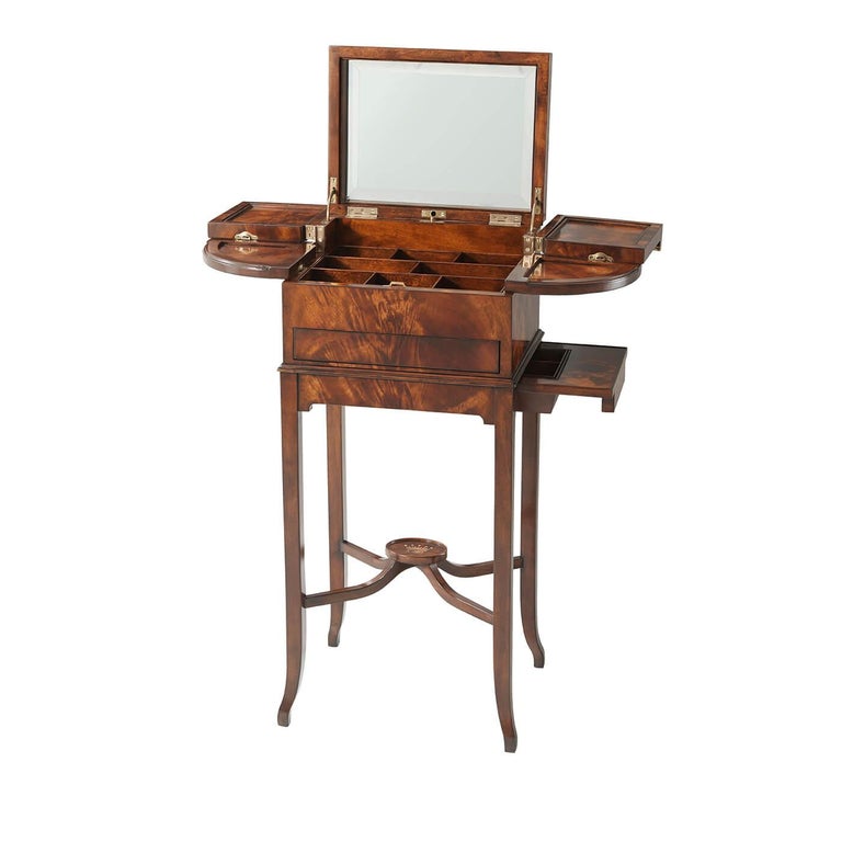 A mahogany dressing table on stand, the hinged top opening to reveal a beveled mirror back, with bowed and square swing panels revealing a fitted interior, with a drawer below and a side bowl drawer to the apron, on splayed legs joined by and 'x'