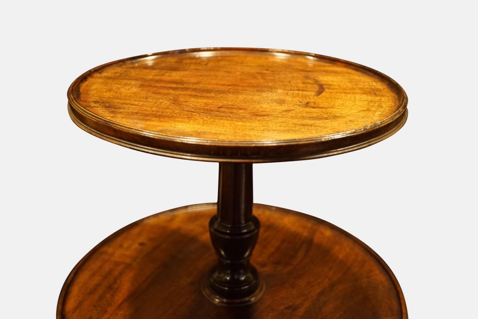 A George III mahogany dumb waiter with three revolving tray tops, vase turned columns and tripod base to original castors, all of excellent color and no splits or repairs,

circa 1775.
 