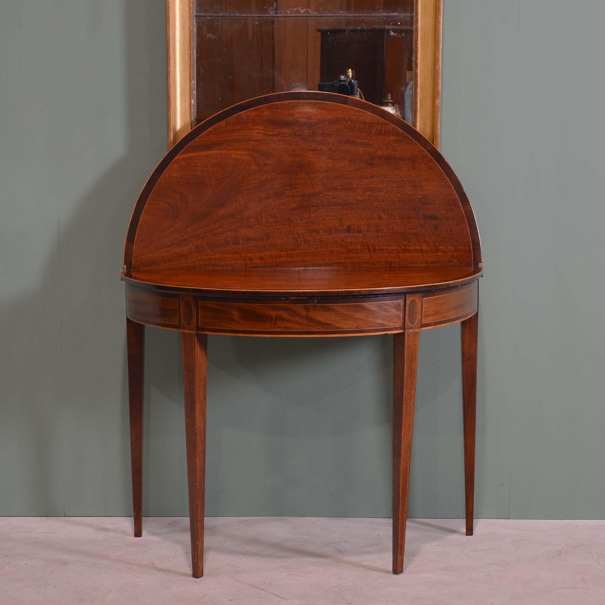 Mesa de té abatible de caoba Jorge III
Mesa abatible en forma de D sobre cuatro patas cuadradas ahusadas, que se abre con una puerta doble, a un interior pulido con bandas cruzadas y encordado de boj.
Inglés, hacia 1790

70 cm de altura, 93 cm de