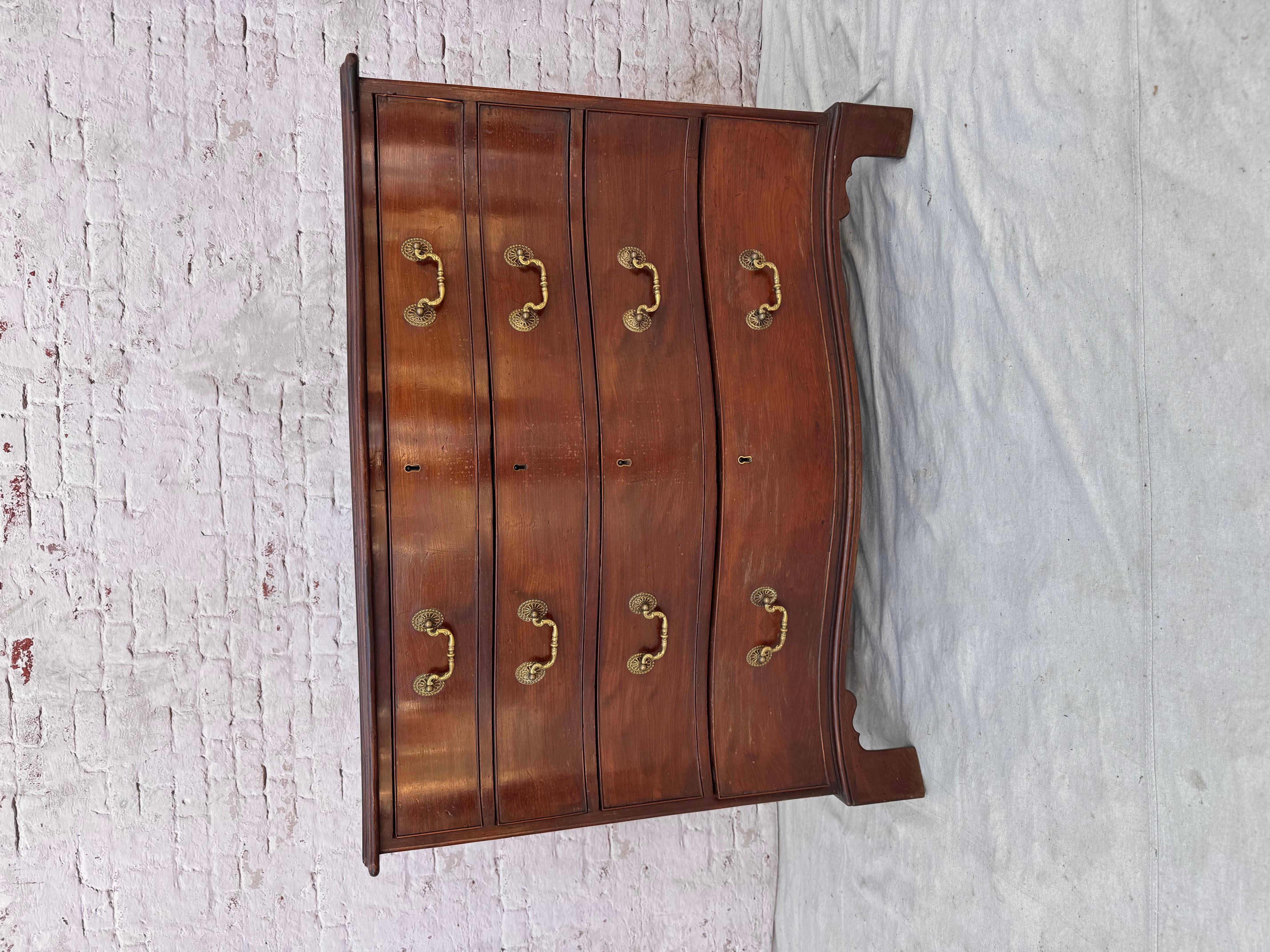 Cassettone di Giorgio III a quattro cassetti in mogano con ferramenta in ottone. La cassapanca ha un piano e un frontale in mogano a serpentina su quattro cassetti. Il petto poggia sui piedi della staffa. Questo pezzo è sia funzionale che decorativo