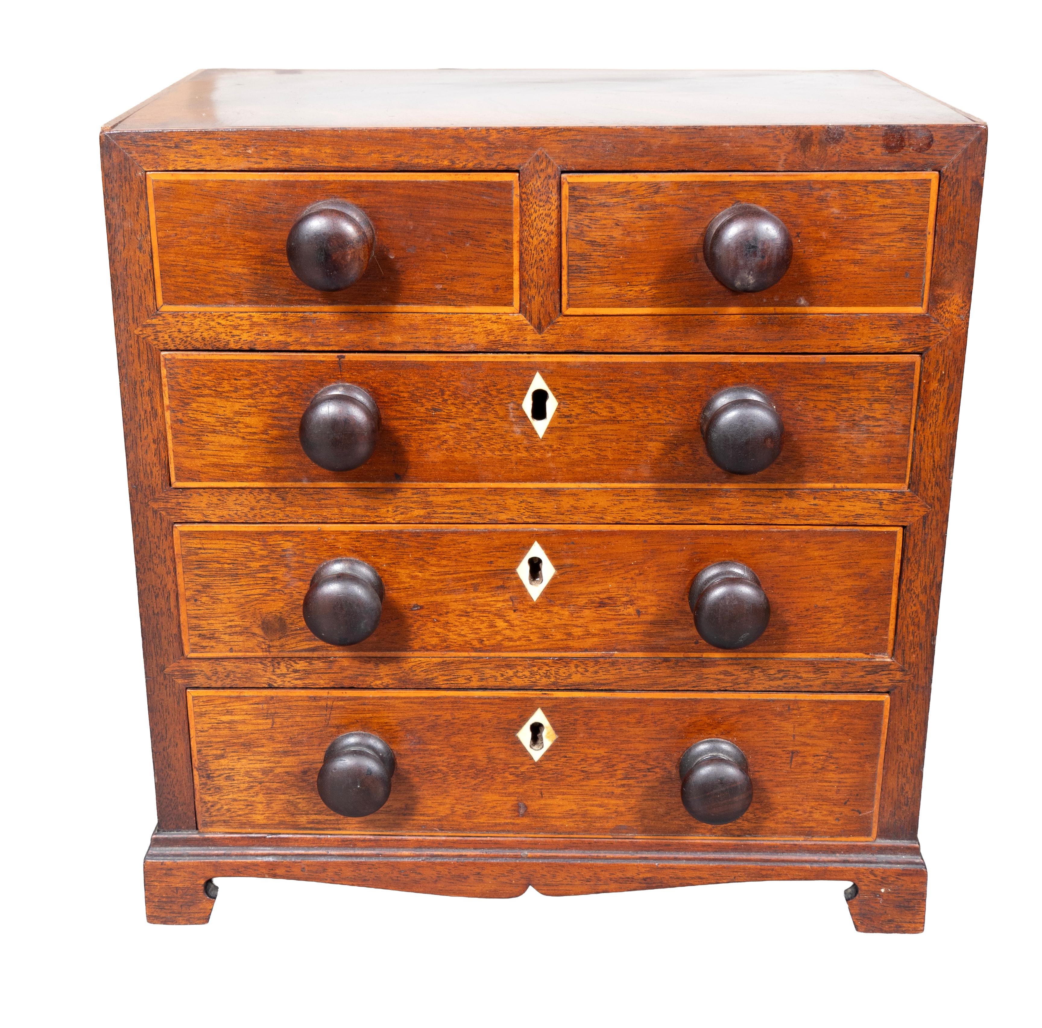Rectangular top and two over three drawers with wood knobs. Bracket feet.